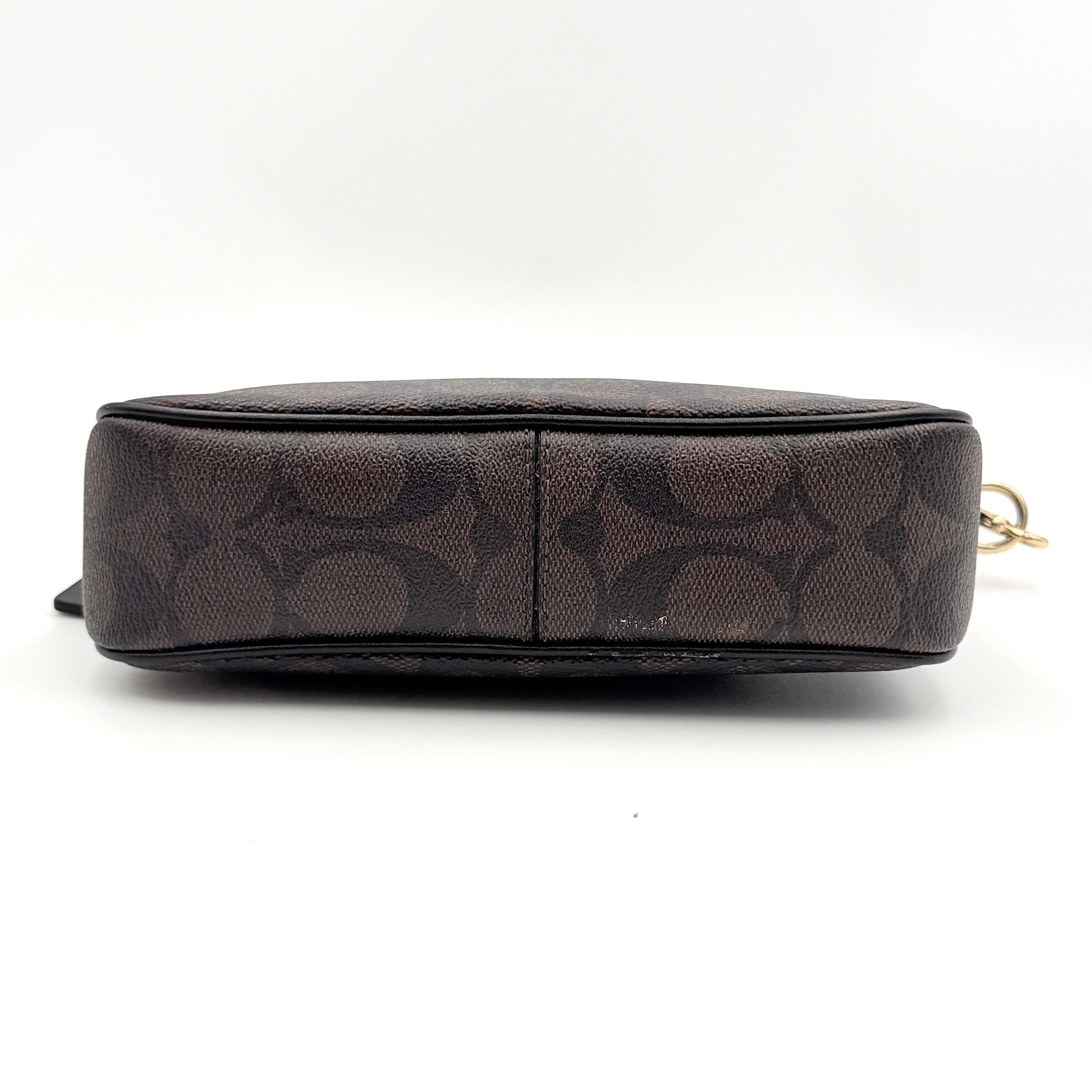 Coach Signature Nolita 19 shoulder bag in brown monogram canvas with black leather strap and gold-tone hardware, shown against a white background.