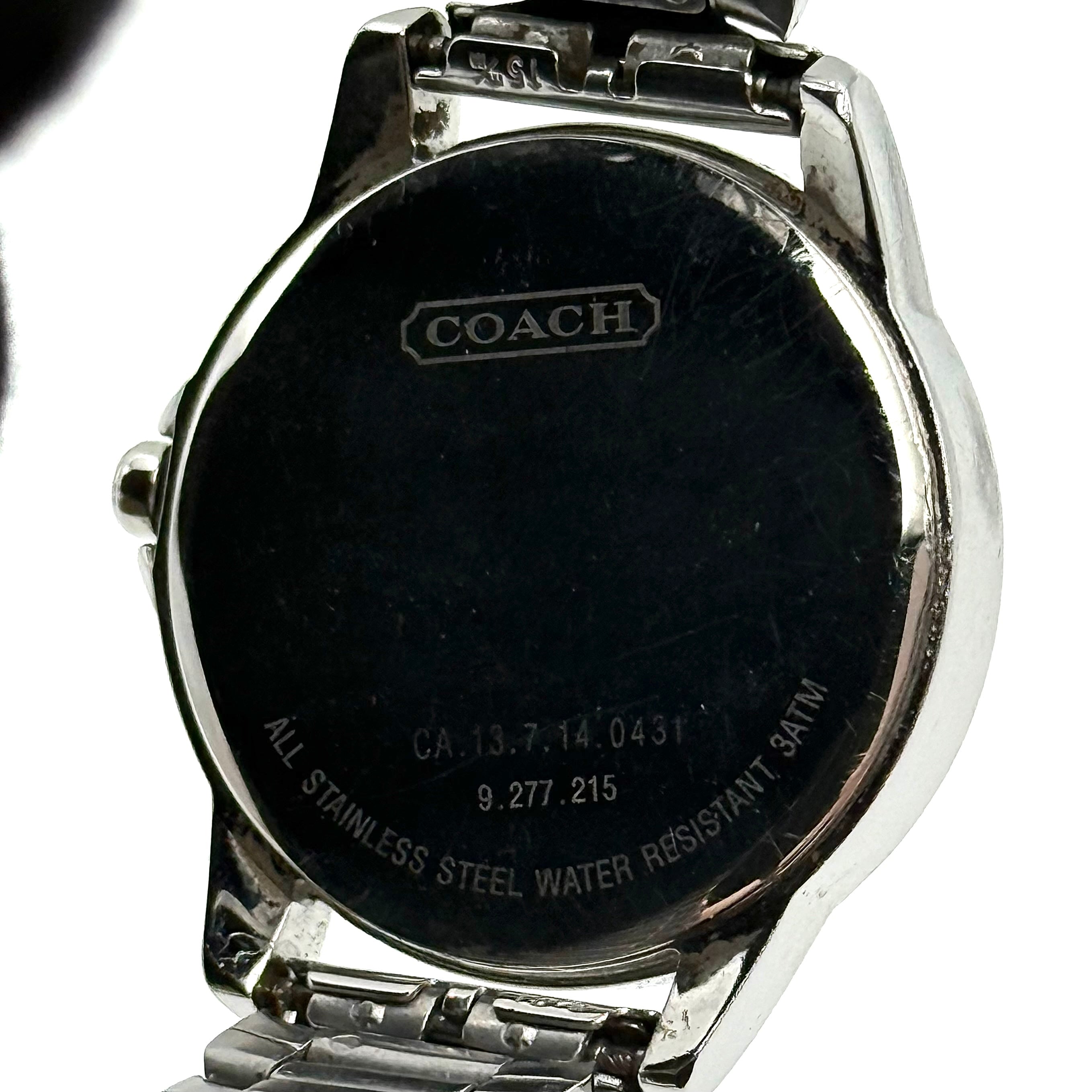 Coach CA.13.7.14.0431 stainless steel watch with brown dial and silver-tone bracelet, presented on a black cushion.