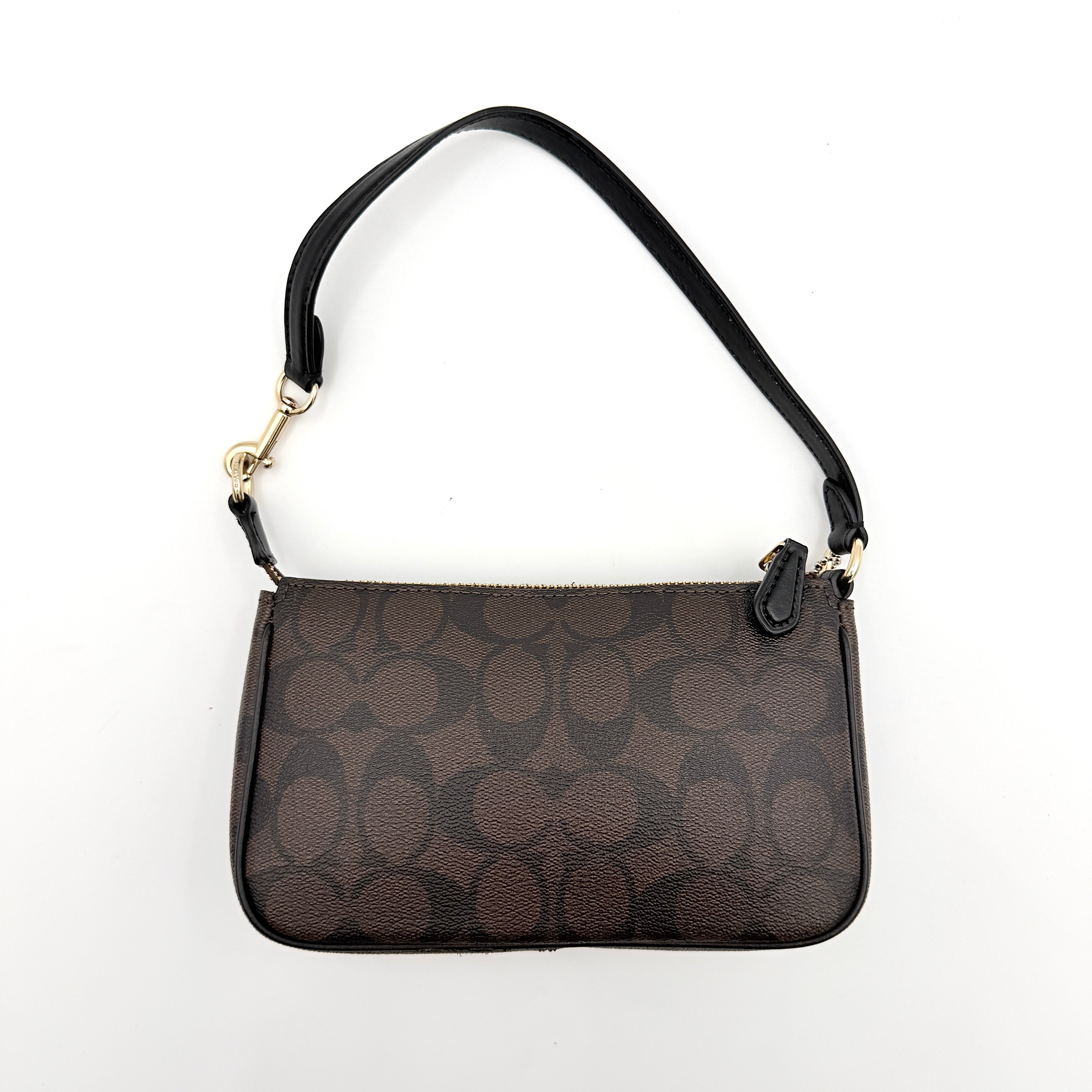 Coach Signature Nolita 19 shoulder bag in brown monogram canvas with black leather strap and gold-tone hardware, shown against a white background.