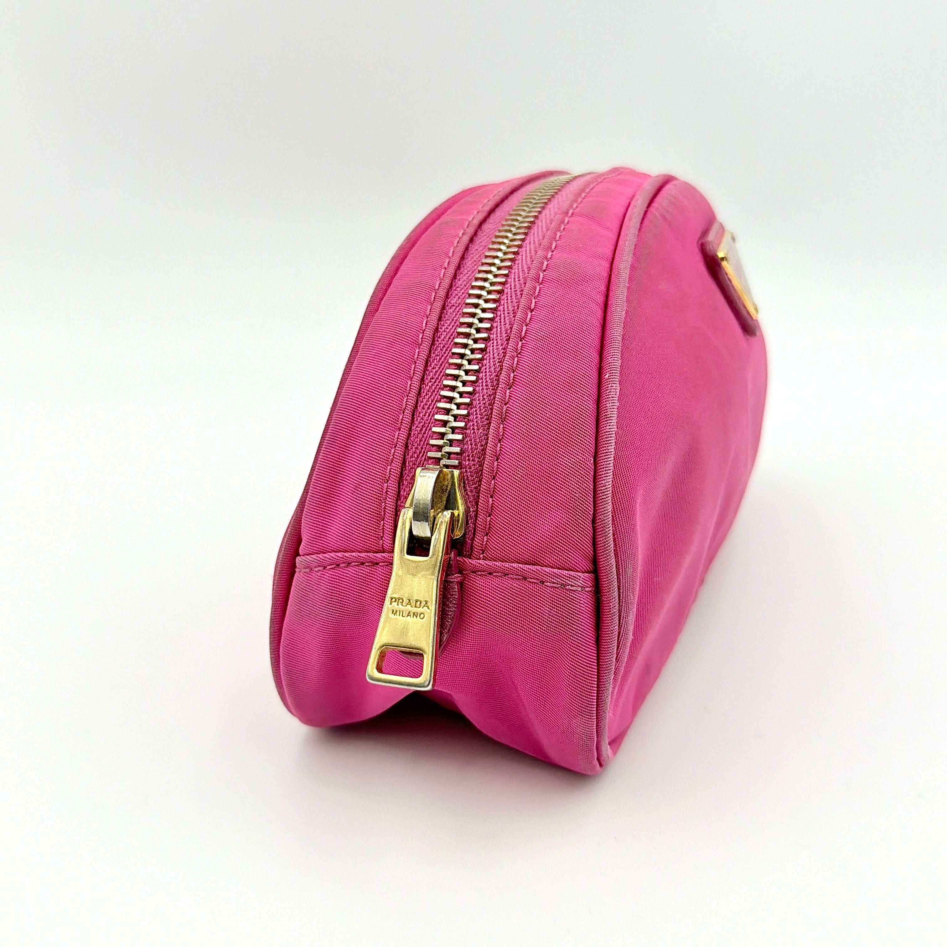 Prada Tessuto Nylon Pouch in vibrant pink with gold-tone hardware and triangle logo, showing visible wear on the exterior.