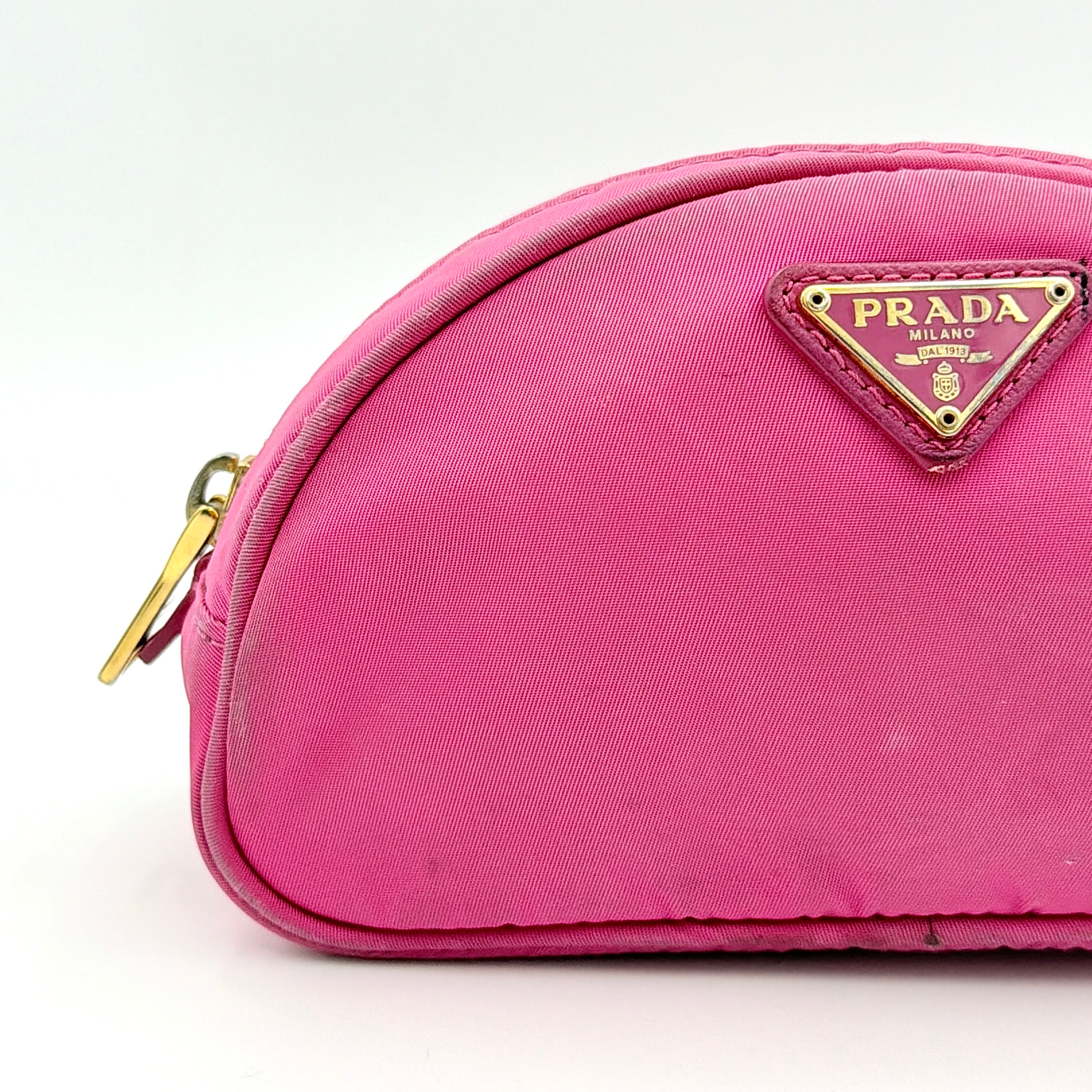Prada Tessuto Nylon Pouch in vibrant pink with gold-tone hardware and triangle logo, showing visible wear on the exterior.