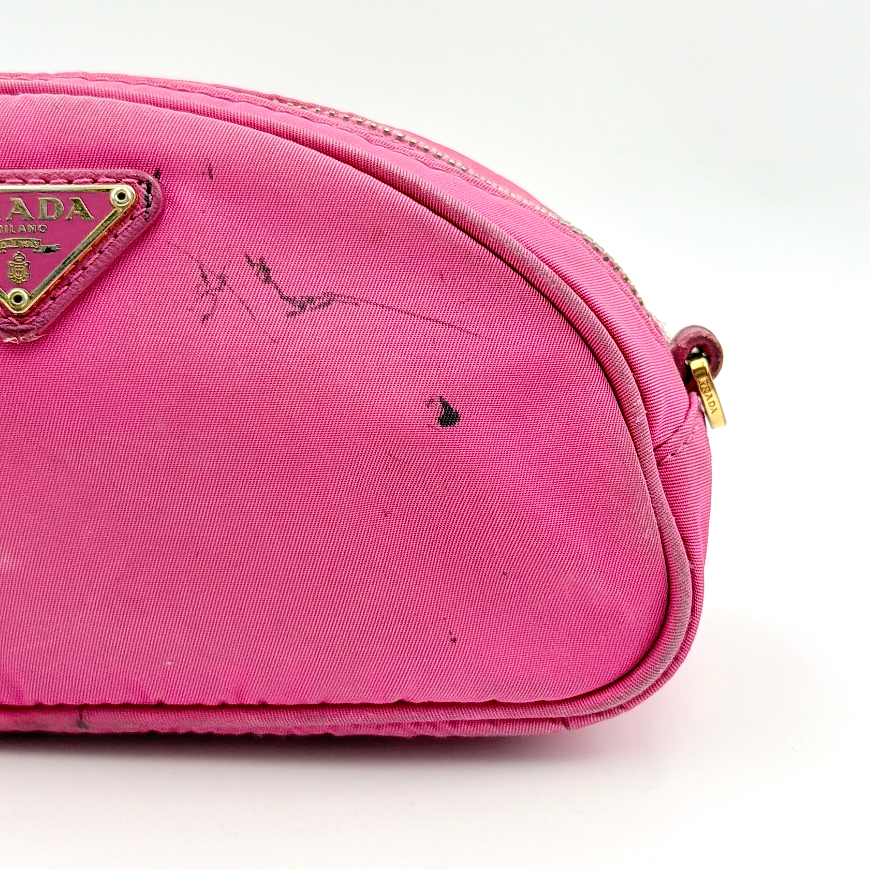 Prada Tessuto Nylon Pouch in vibrant pink with gold-tone hardware and triangle logo, showing visible wear on the exterior.