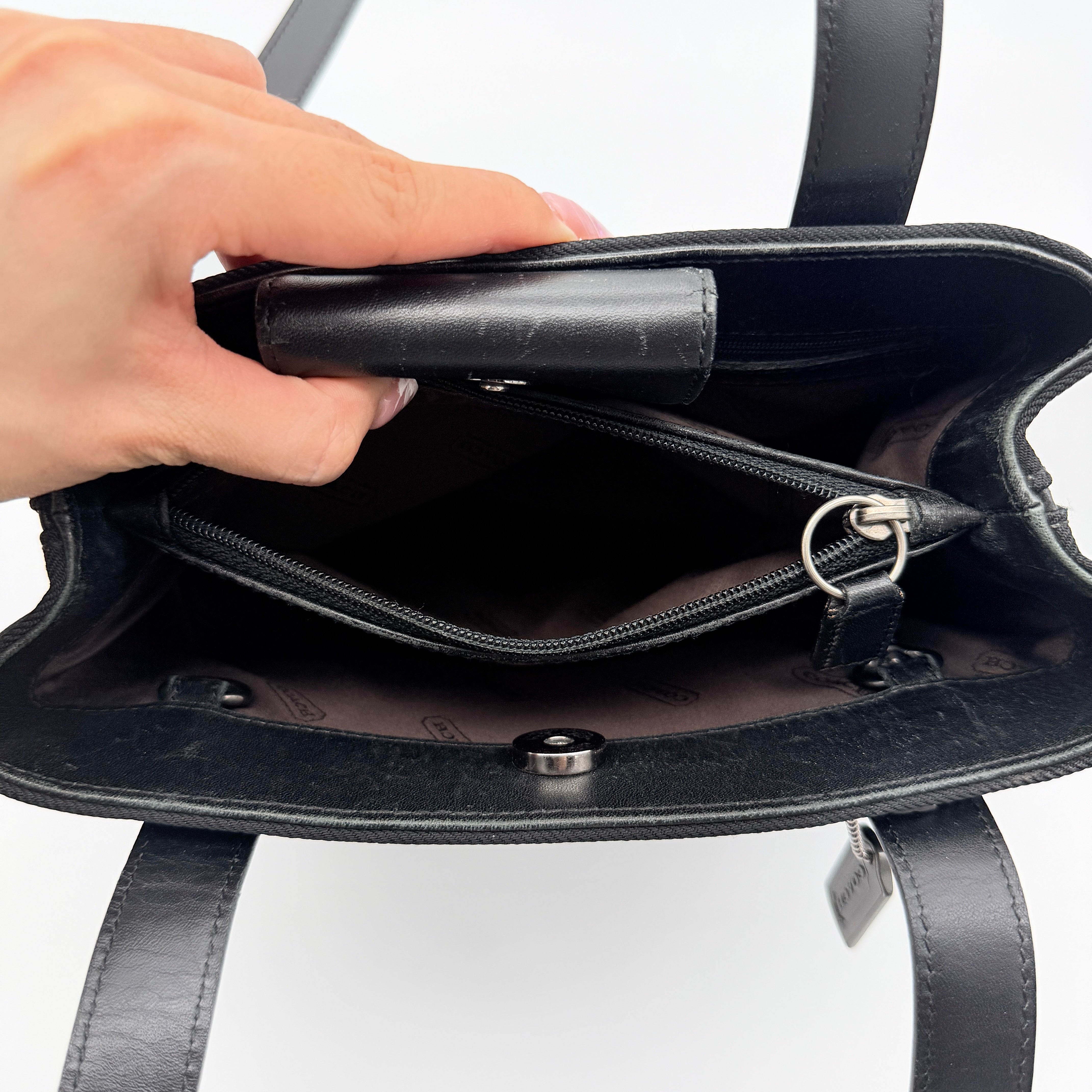 Coach Mercer Nylon Tote Bag in black with leather handles and silver Coach tag, photographed on a white background.