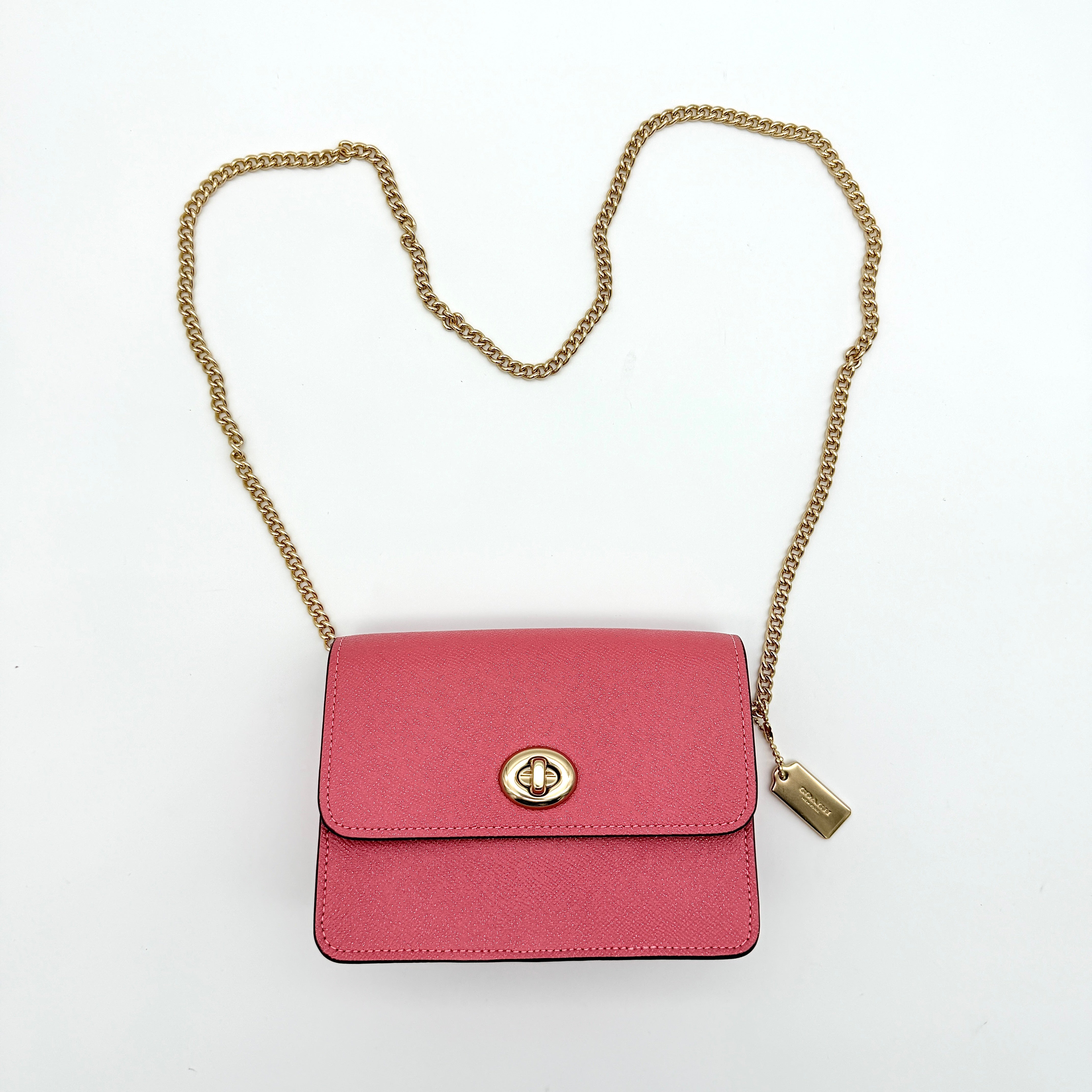 Coach Bowery Turnlock shoulder bag in pink saffiano leather with a gold-tone chain strap and signature Coach hangtag.