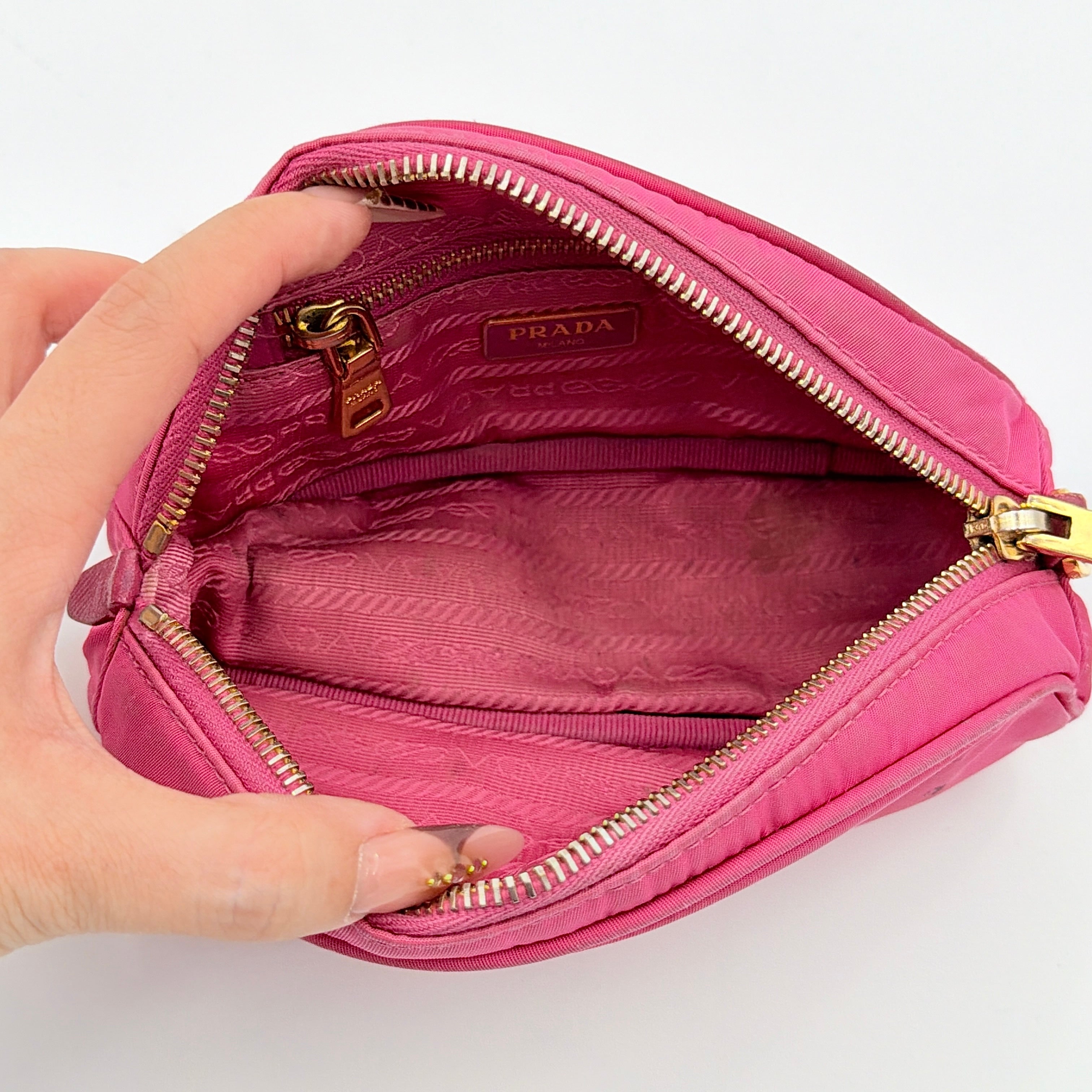 Prada Tessuto Nylon Pouch in vibrant pink with gold-tone hardware and triangle logo, showing visible wear on the exterior.