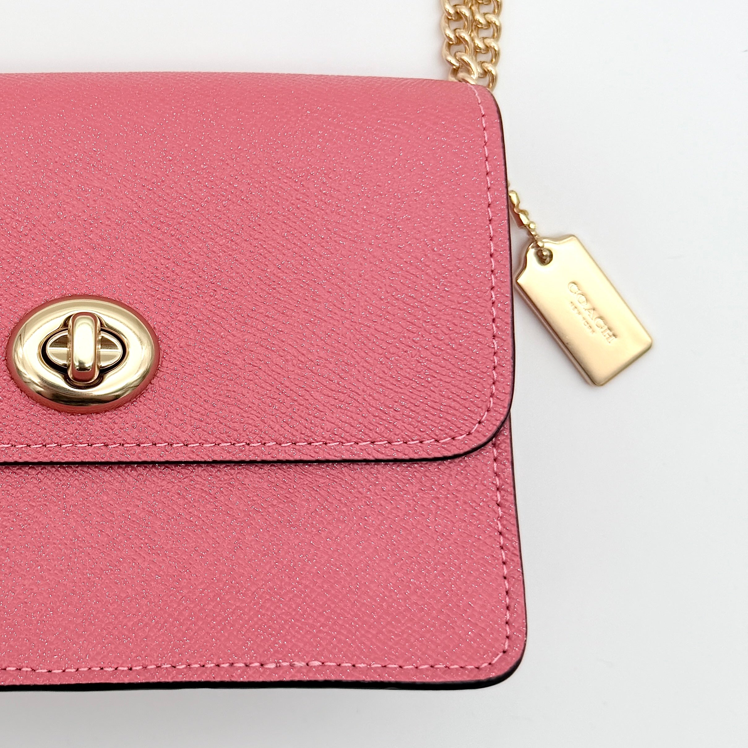Coach Bowery Turnlock shoulder bag in pink saffiano leather with a gold-tone chain strap and signature Coach hangtag.