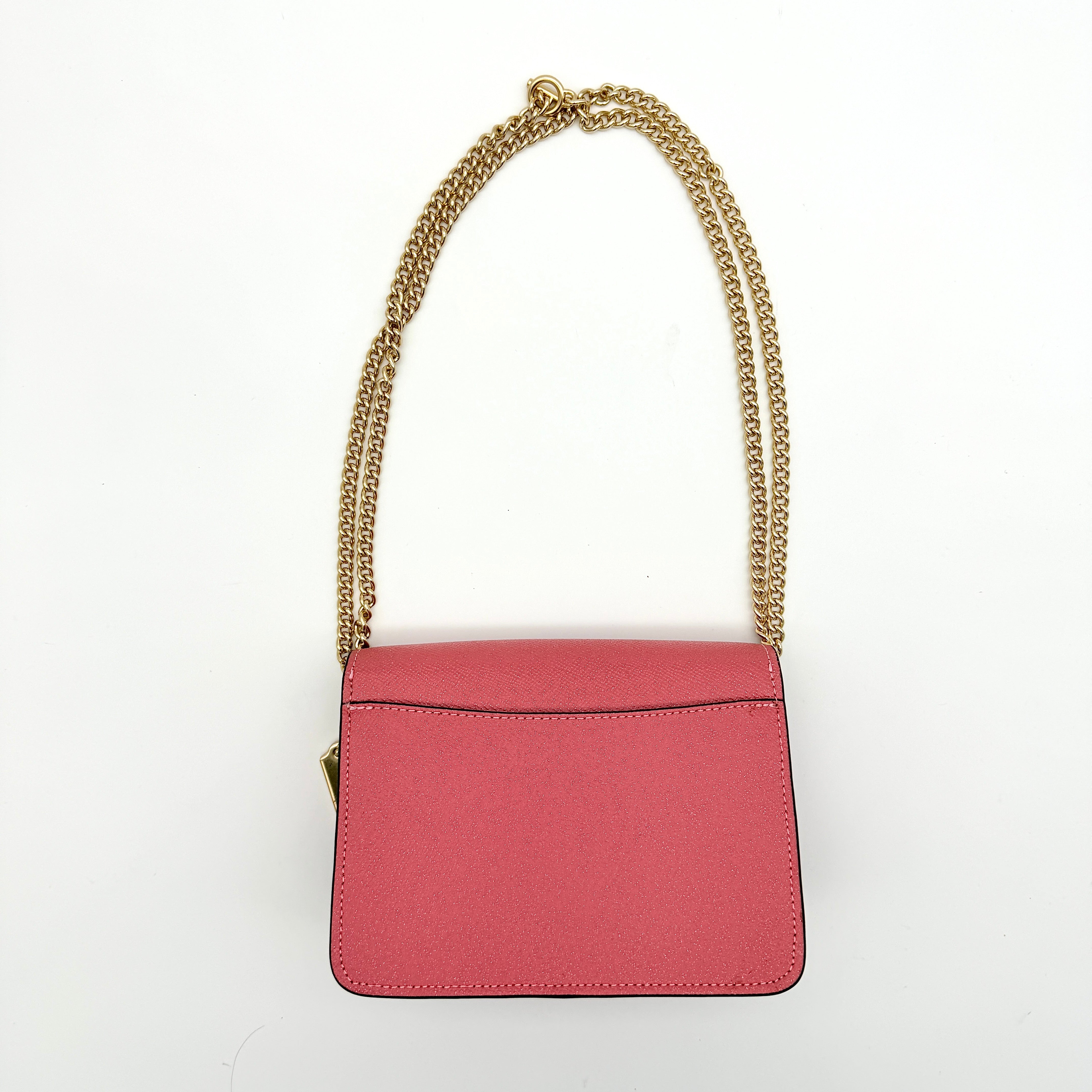 Coach Bowery Turnlock shoulder bag in pink saffiano leather with a gold-tone chain strap and signature Coach hangtag.