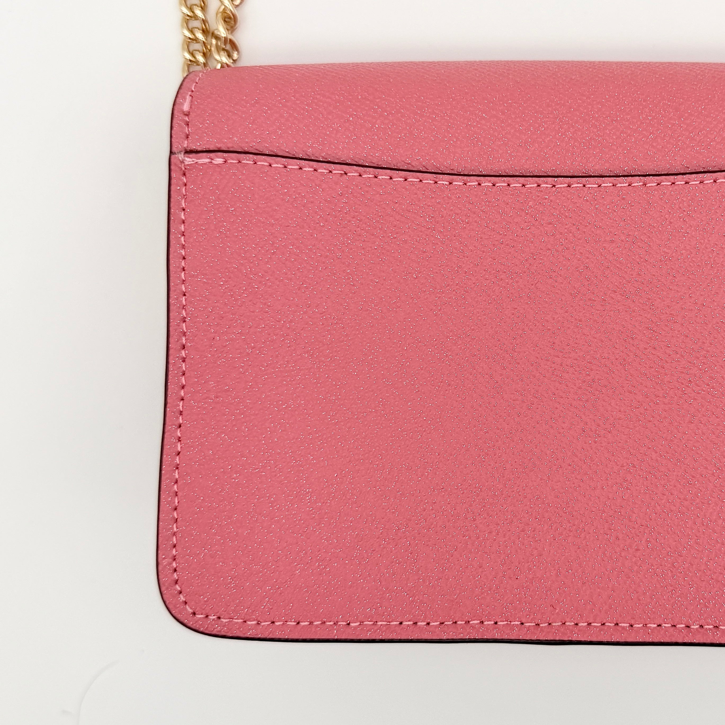 Coach Bowery Turnlock shoulder bag in pink saffiano leather with a gold-tone chain strap and signature Coach hangtag.