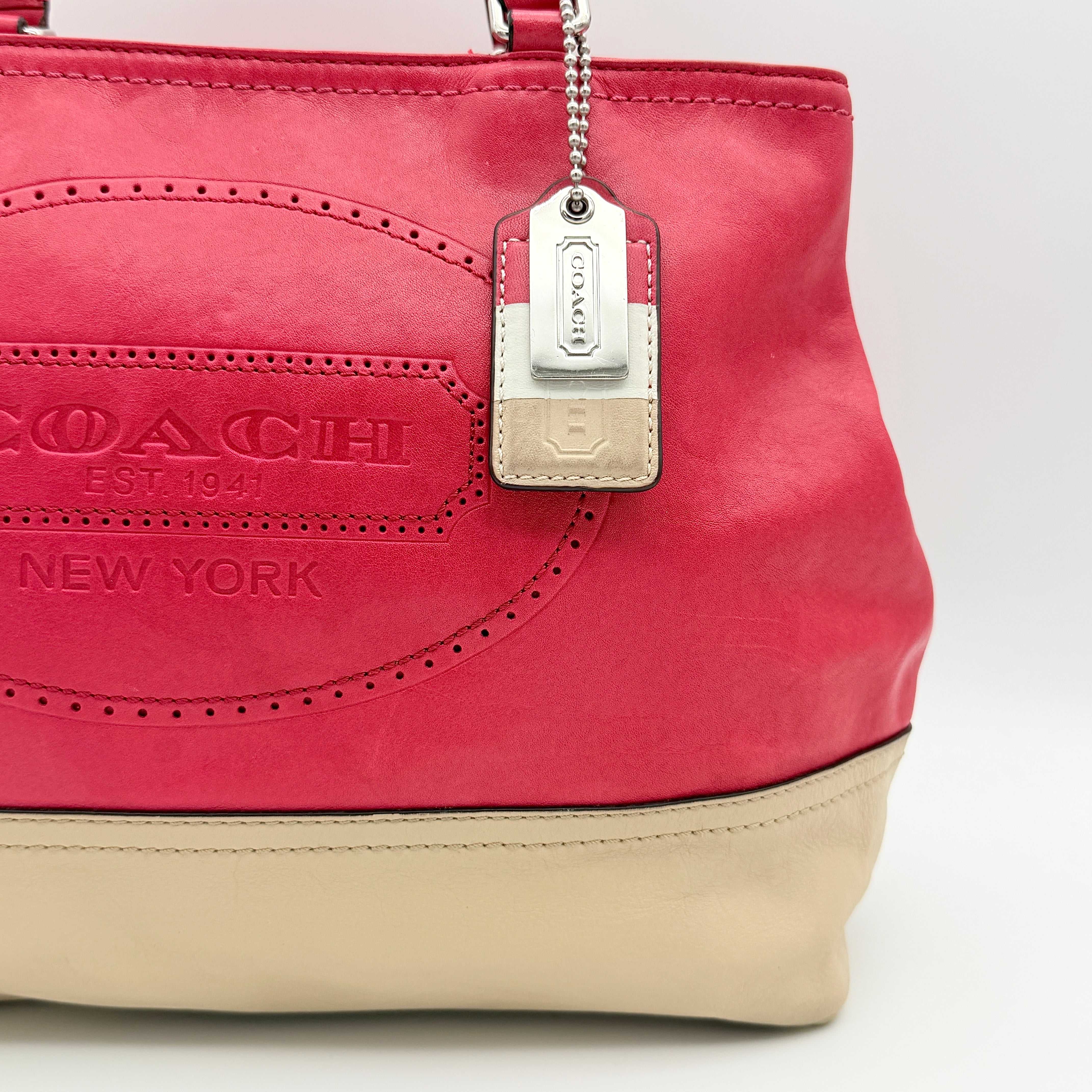 Coach Hamptons Weekend Perforated Tote in red and cream leather with dual top handles and silver hardware.