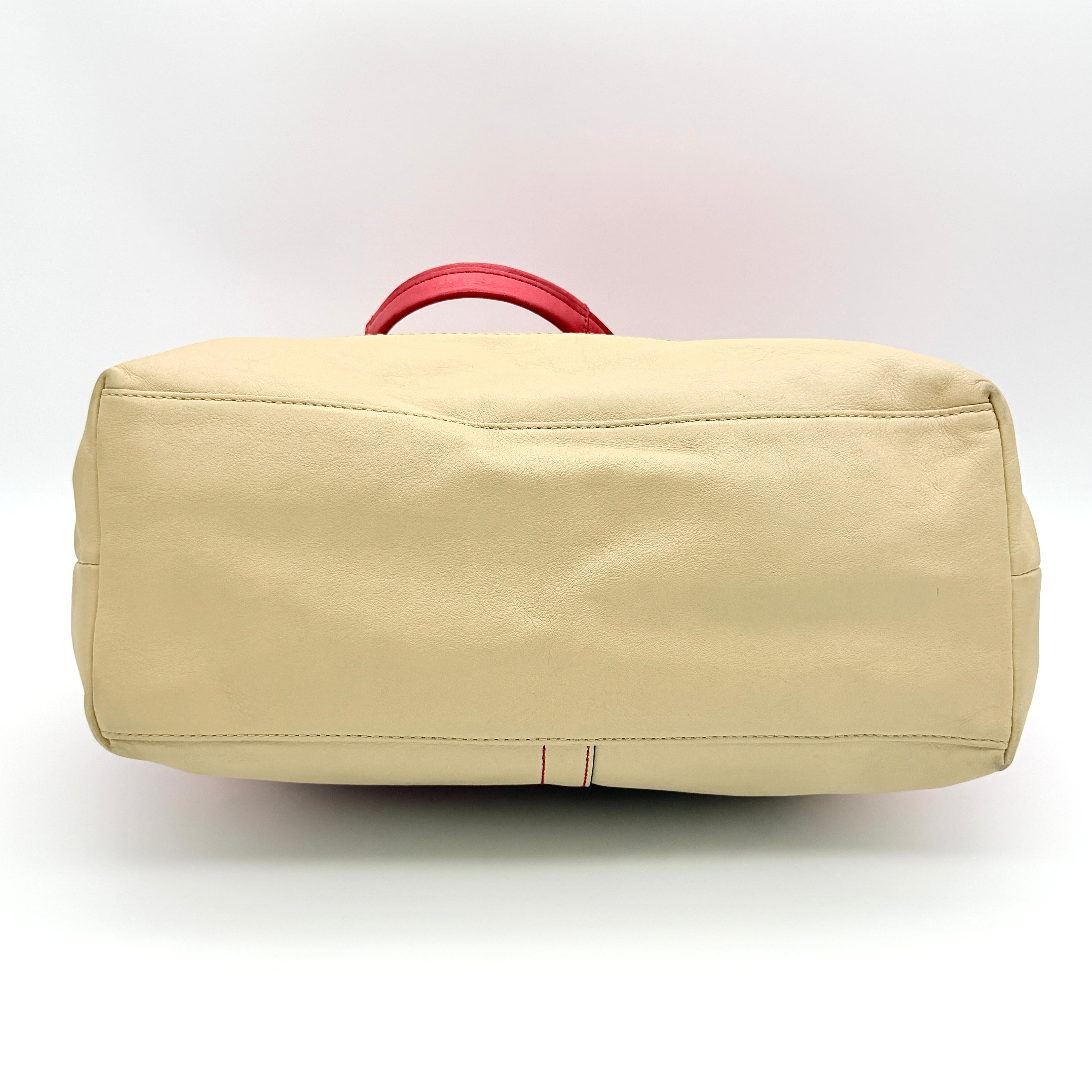 Coach Hamptons Weekend Perforated Tote in red and cream leather with dual top handles and silver hardware.