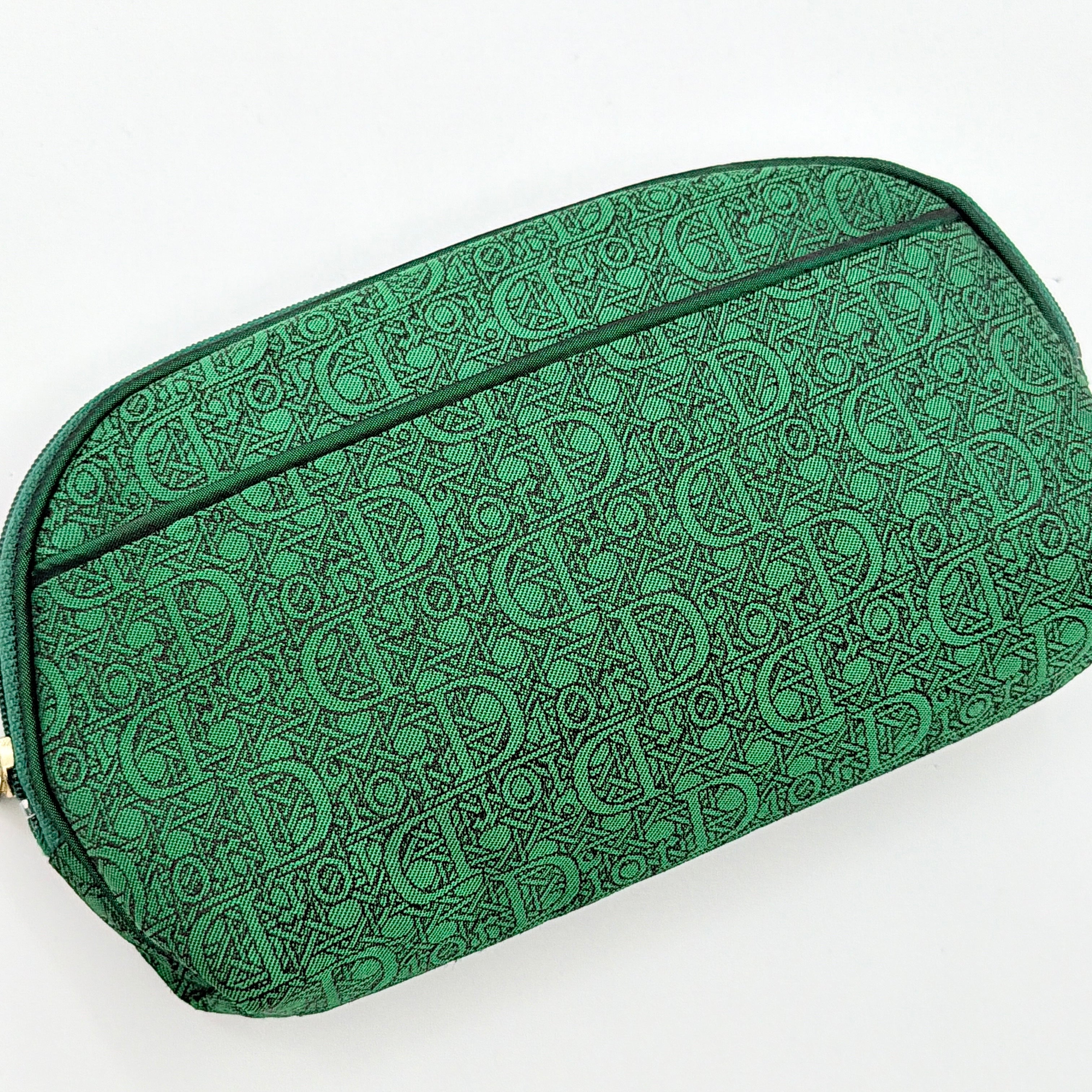 Green Christian Dior Oblique cosmetic pouch with monogram canvas and gold-tone zip, shown from the front.