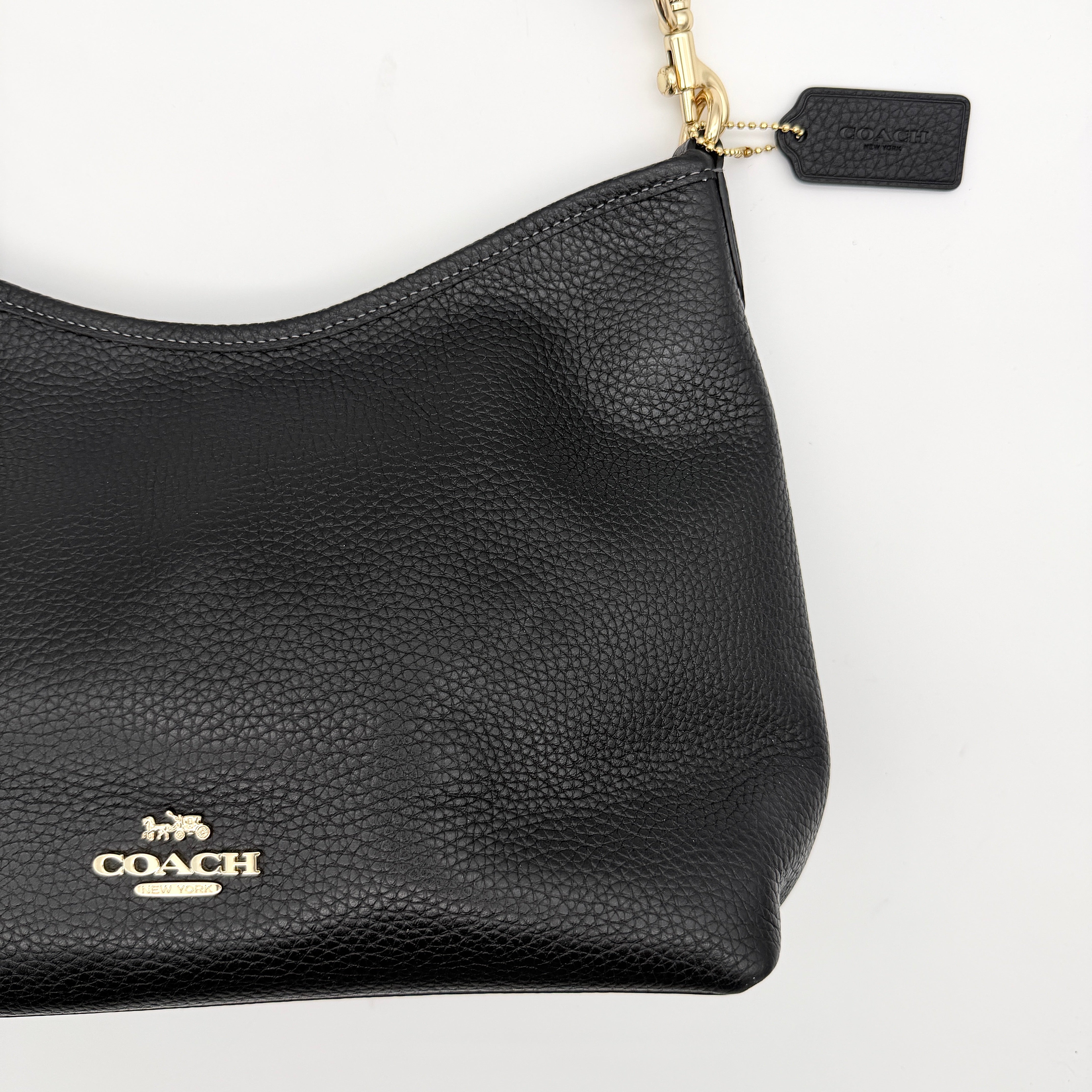 Coach Signature Laurel Shoulder Bag in black pebbled leather with gold hardware and a top zip closure.