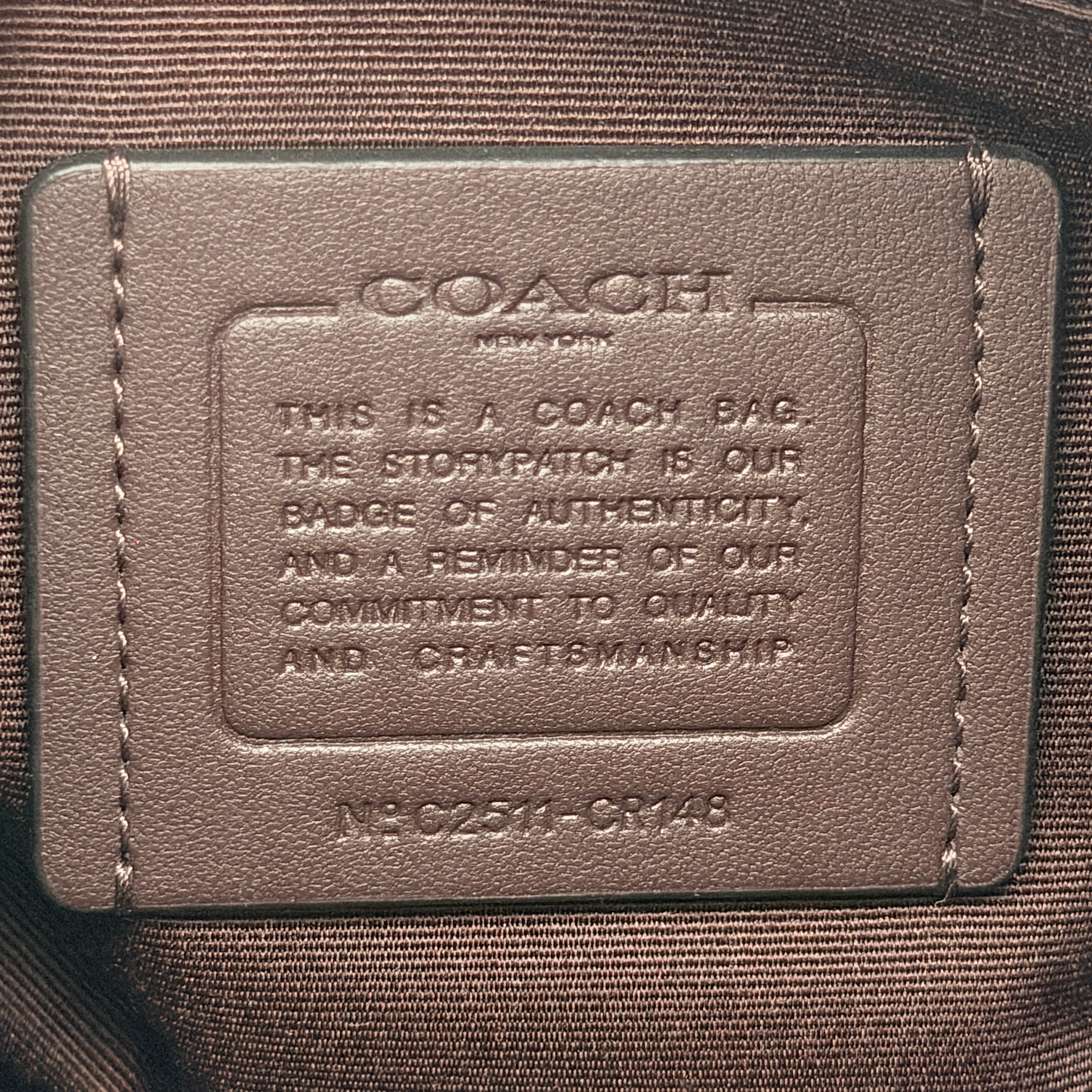 Coach Signature Laurel Shoulder Bag in black pebbled leather with gold hardware and a top zip closure.