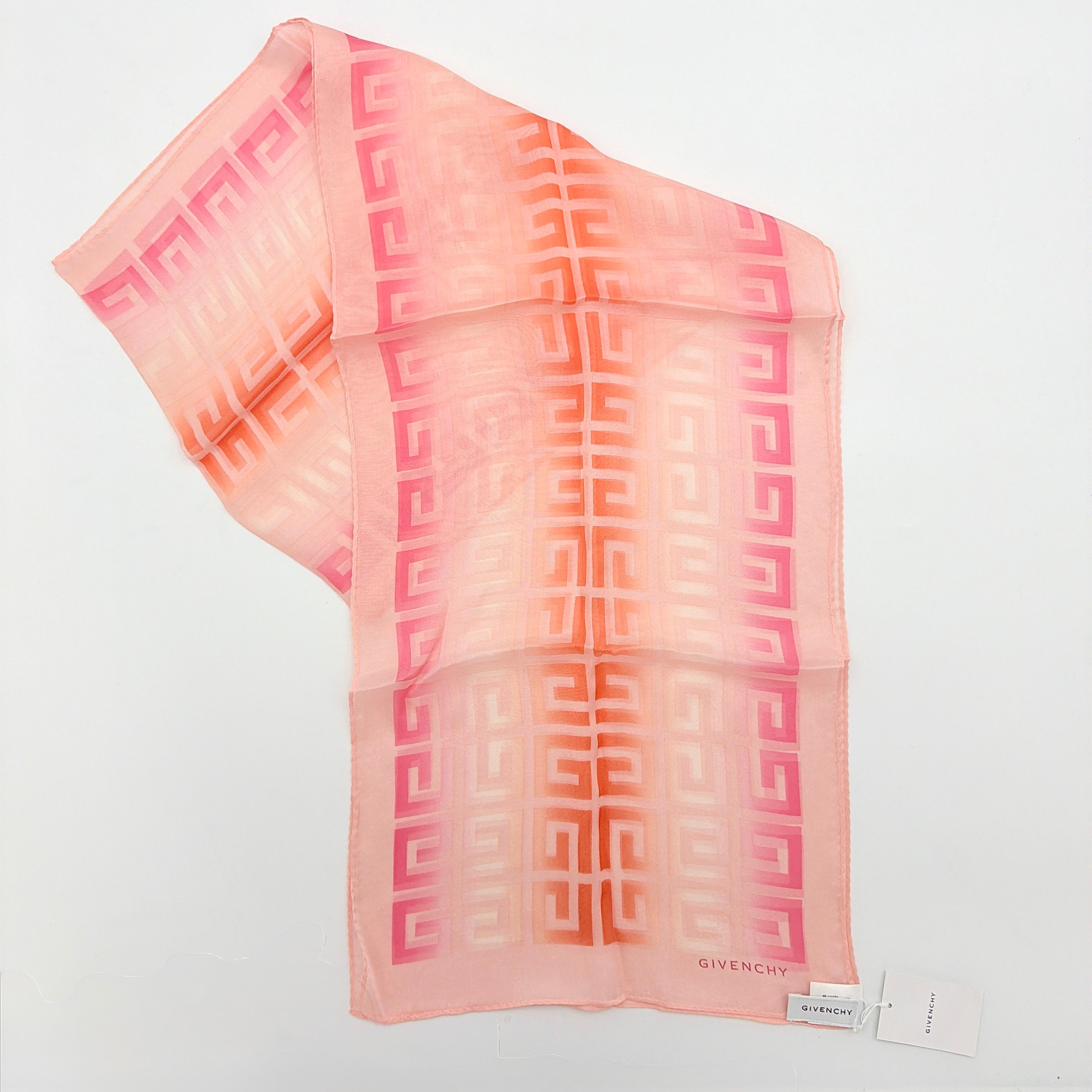 Givenchy silk scarf in pink with orange monogram pattern, showing the full length and original tags attached.