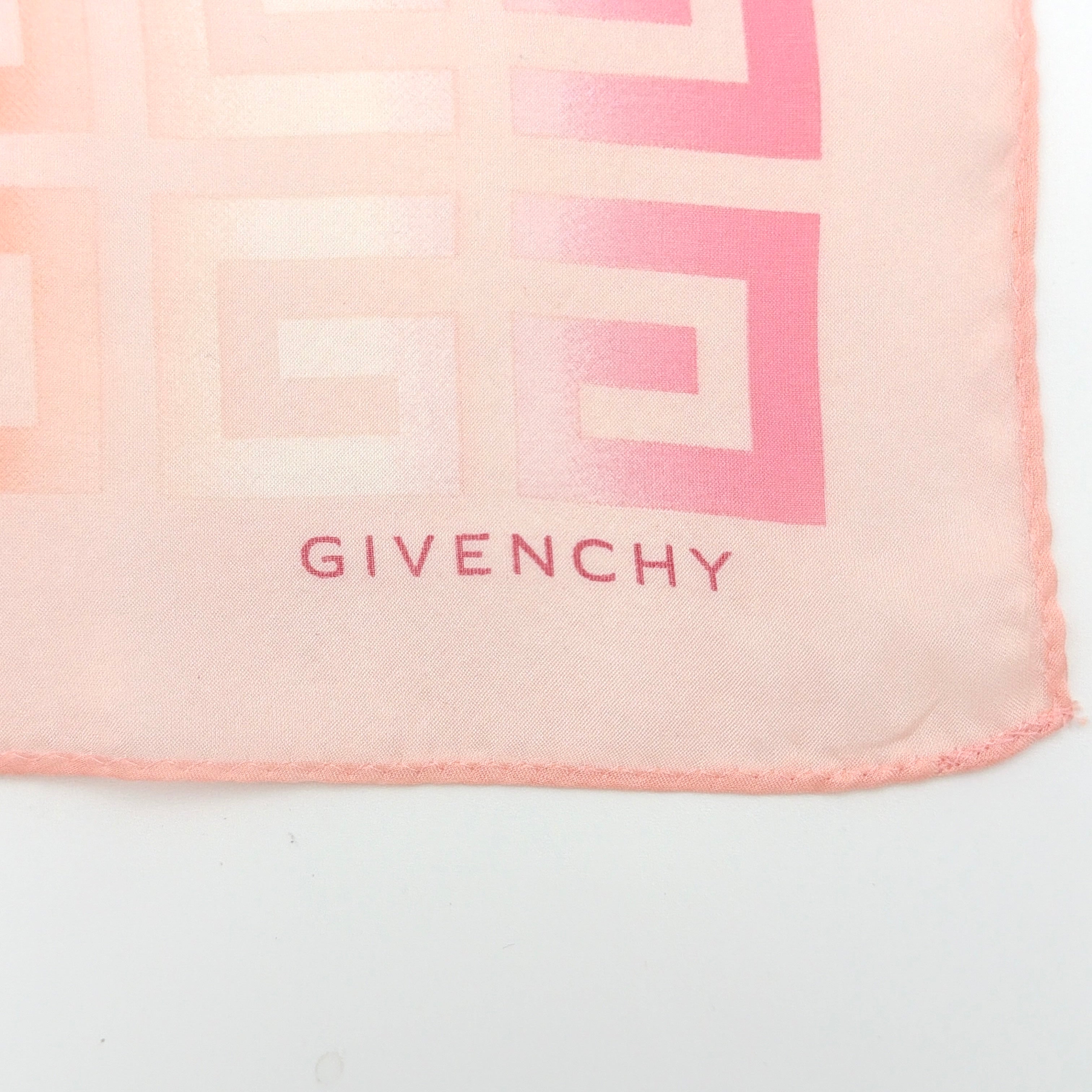 Givenchy silk scarf in pink with orange monogram pattern, showing the full length and original tags attached.