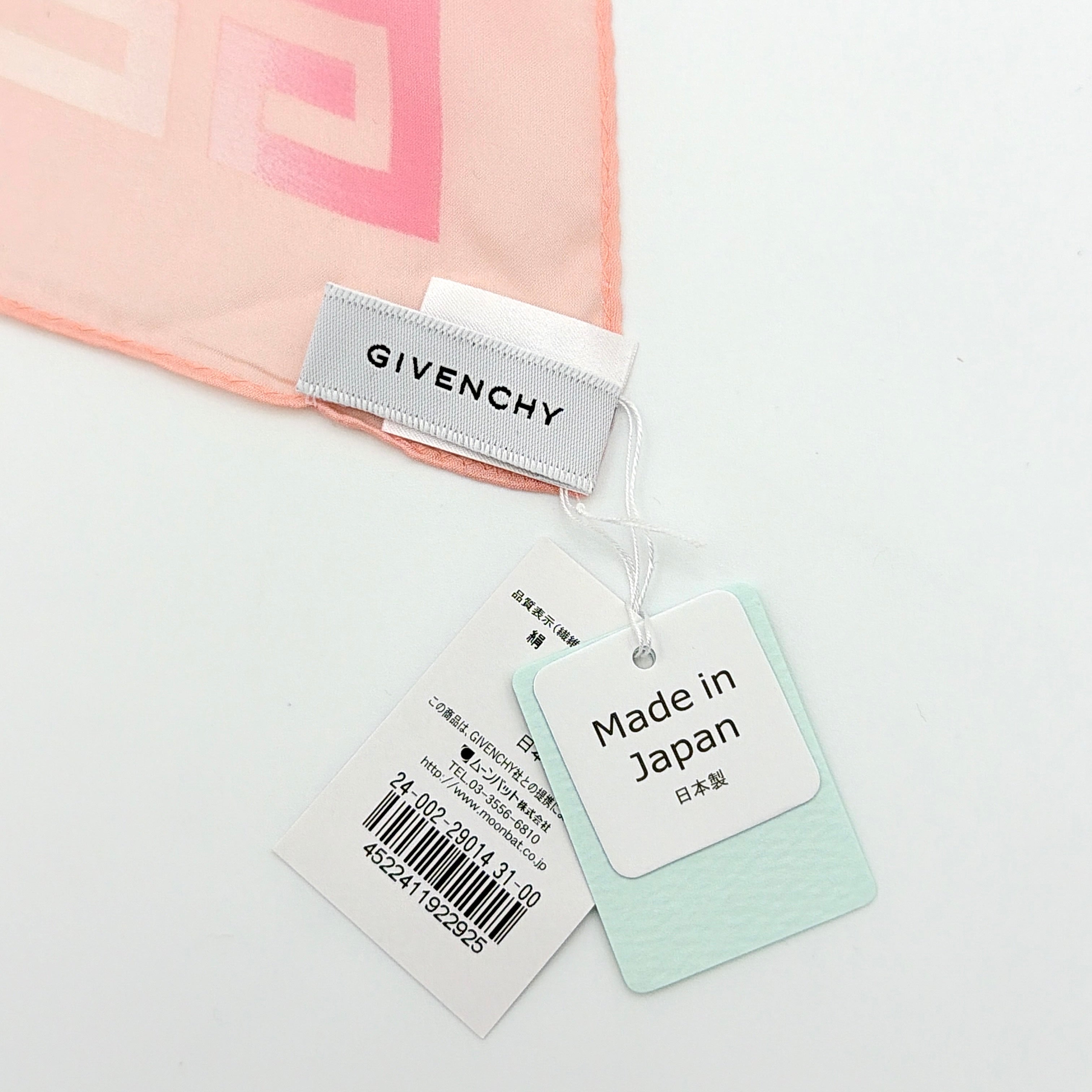 Givenchy silk scarf in pink with orange monogram pattern, showing the full length and original tags attached.