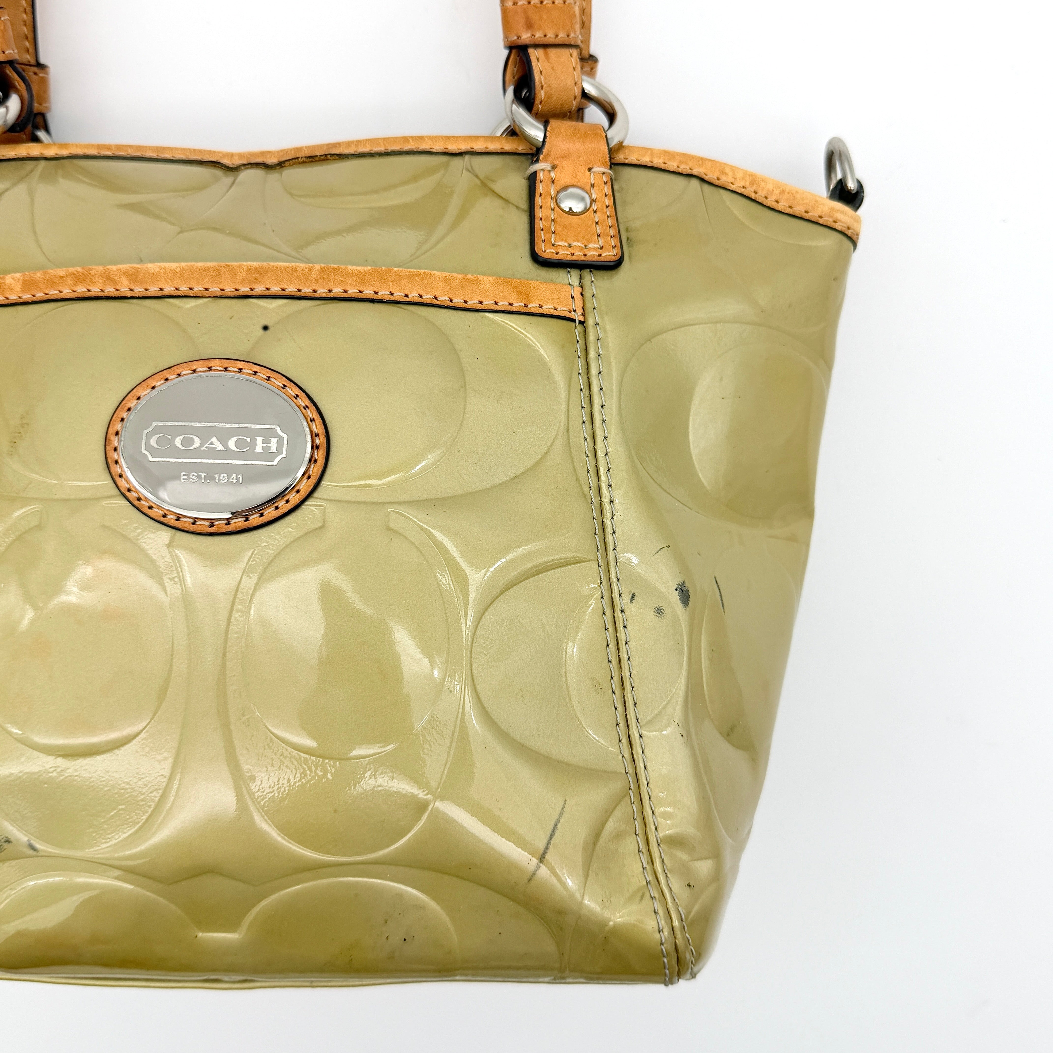 Coach Peyton embossed patent shoulder bag in yellow with tan leather trim and double handles, shown against a white background.