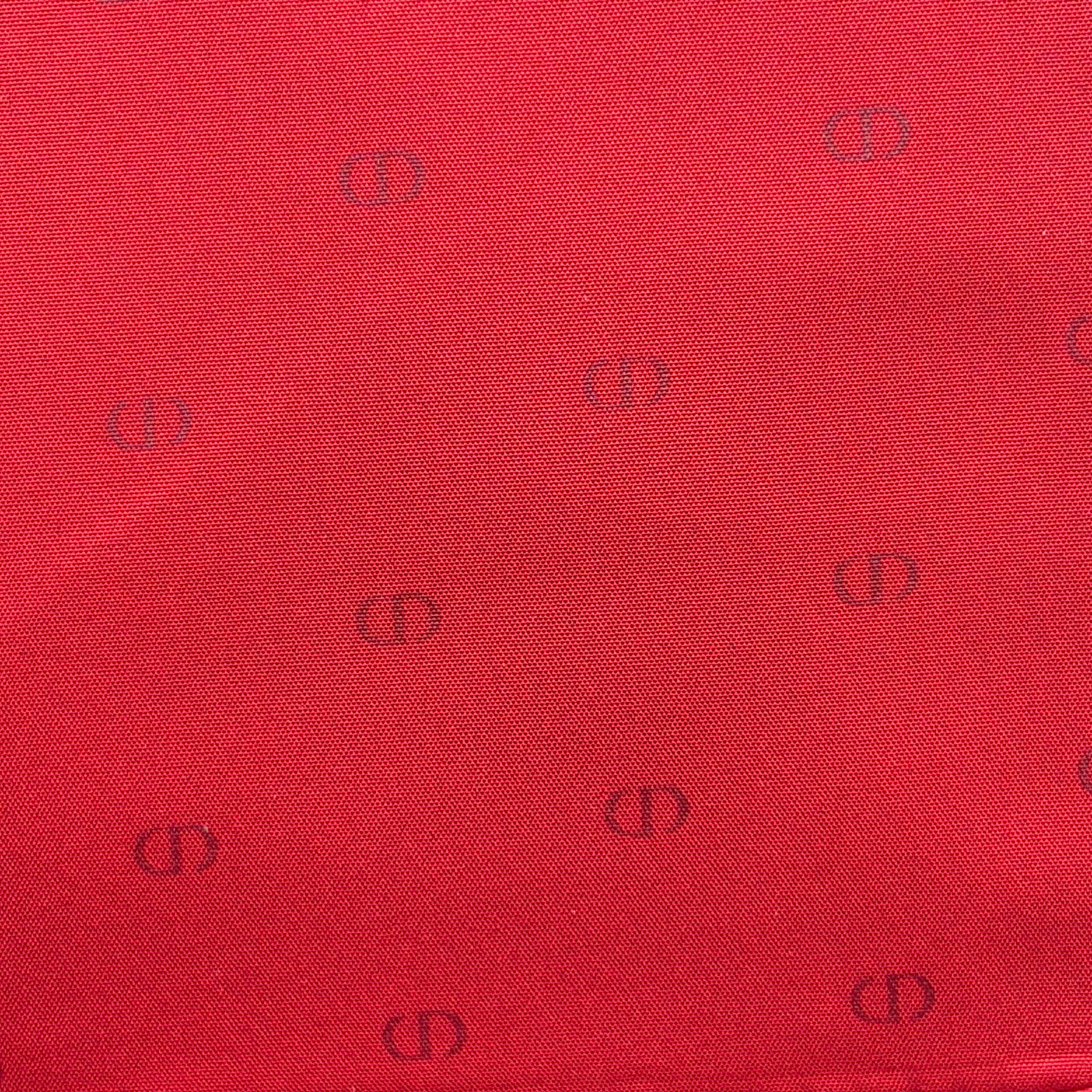 Christian Dior patent leather cosmetic pouch in glossy red with embossed DIOR logo and gold zip hardware.