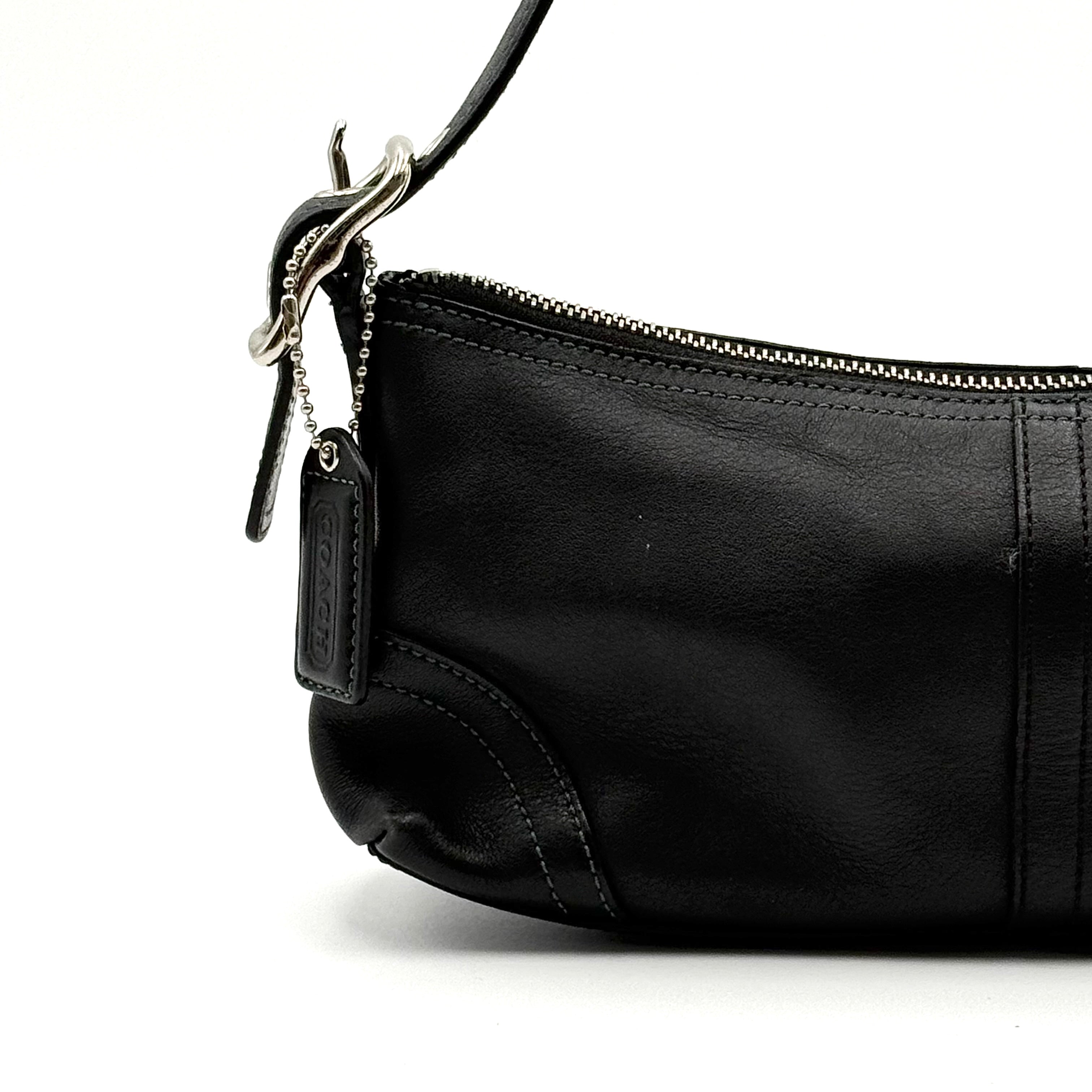 Coach Hampton Demi Baguette shoulder bag in smooth black leather with a curved top handle and silver-tone hardware.