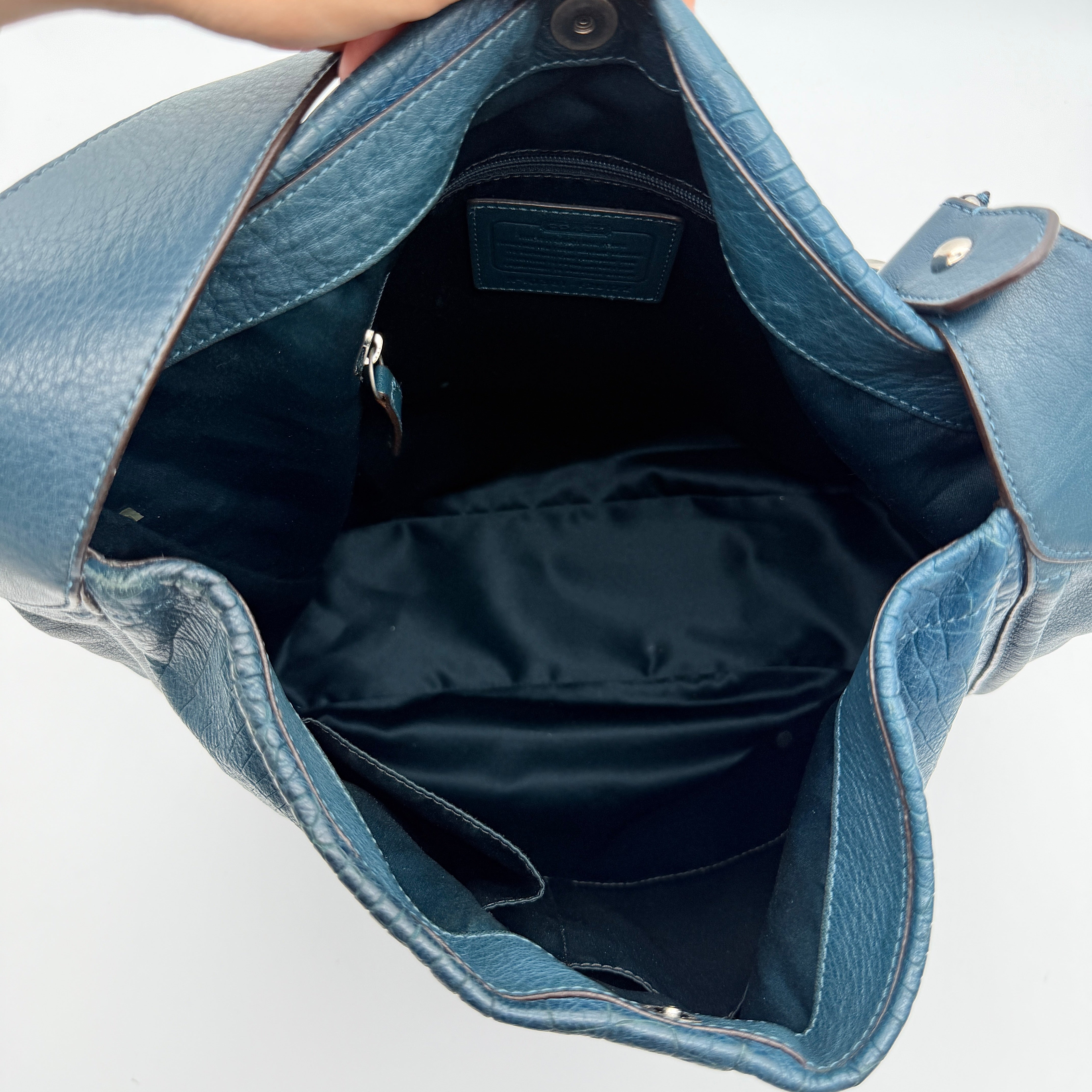 Coach Avery croc-embossed blue leather hobo shoulder bag with single handle and silver hardware against a white background.
