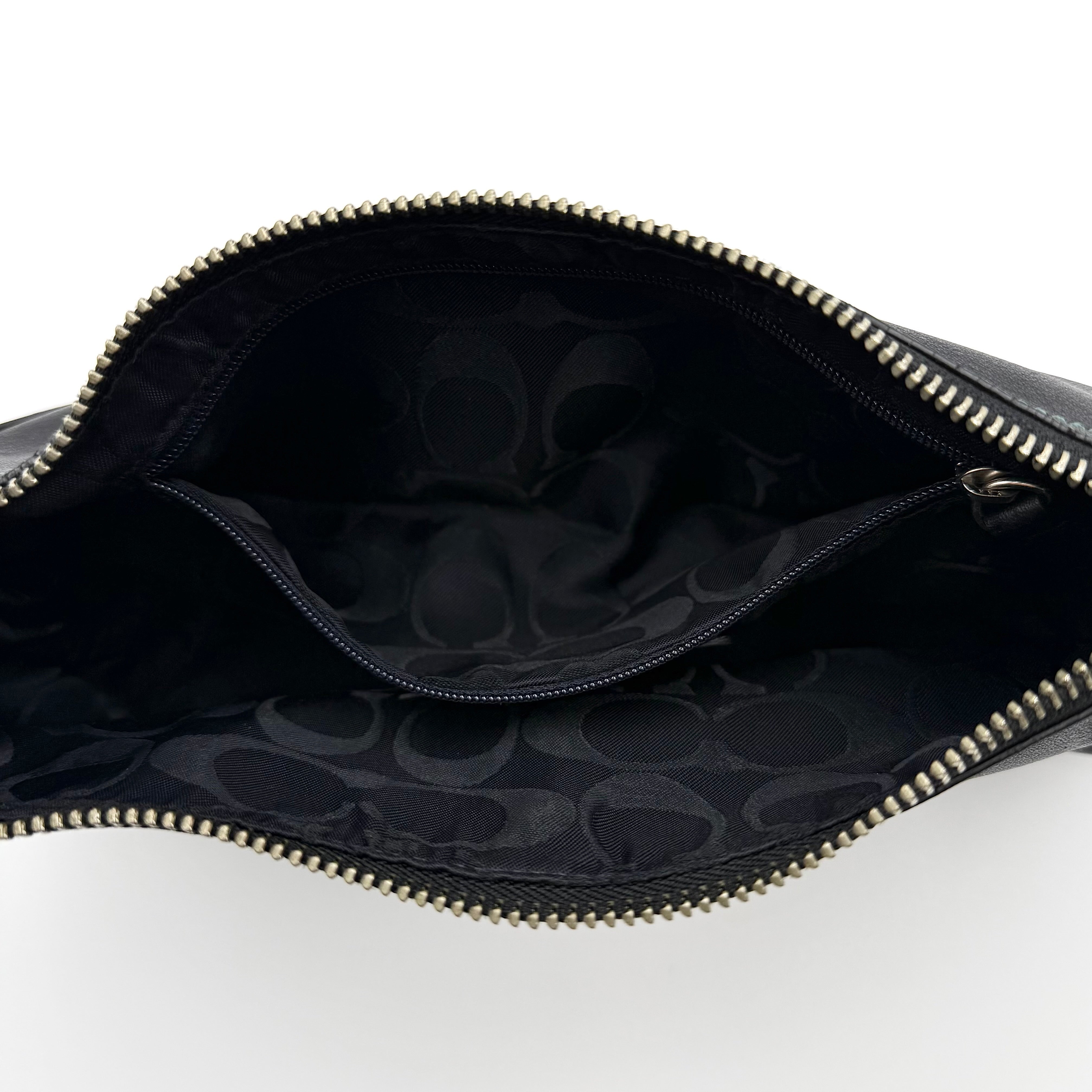 Coach Hampton Demi Baguette shoulder bag in smooth black leather with a curved top handle and silver-tone hardware.