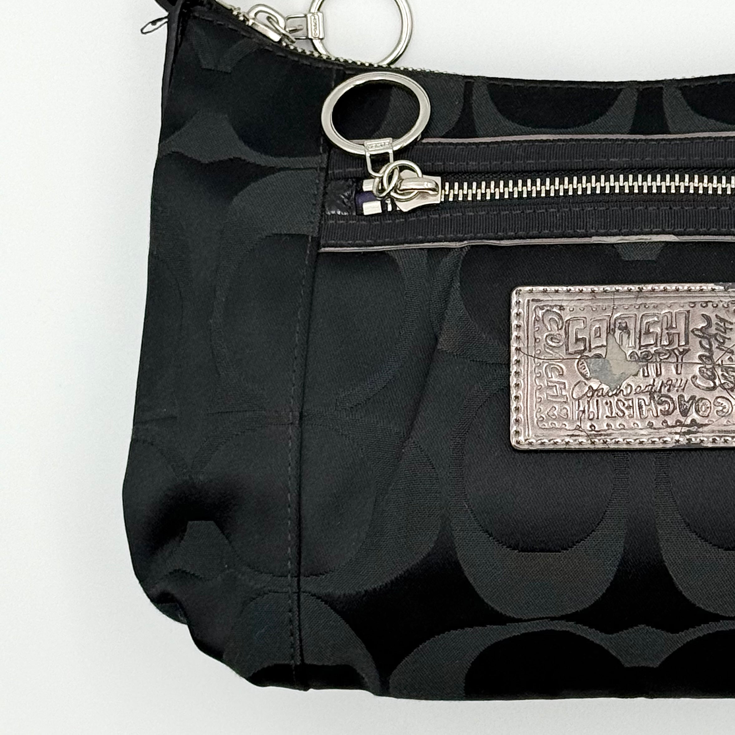 Coach black Signature Poppy Shoulder Bag with silver hardware, Coach tags, and tonal jacquard finish on a white background.