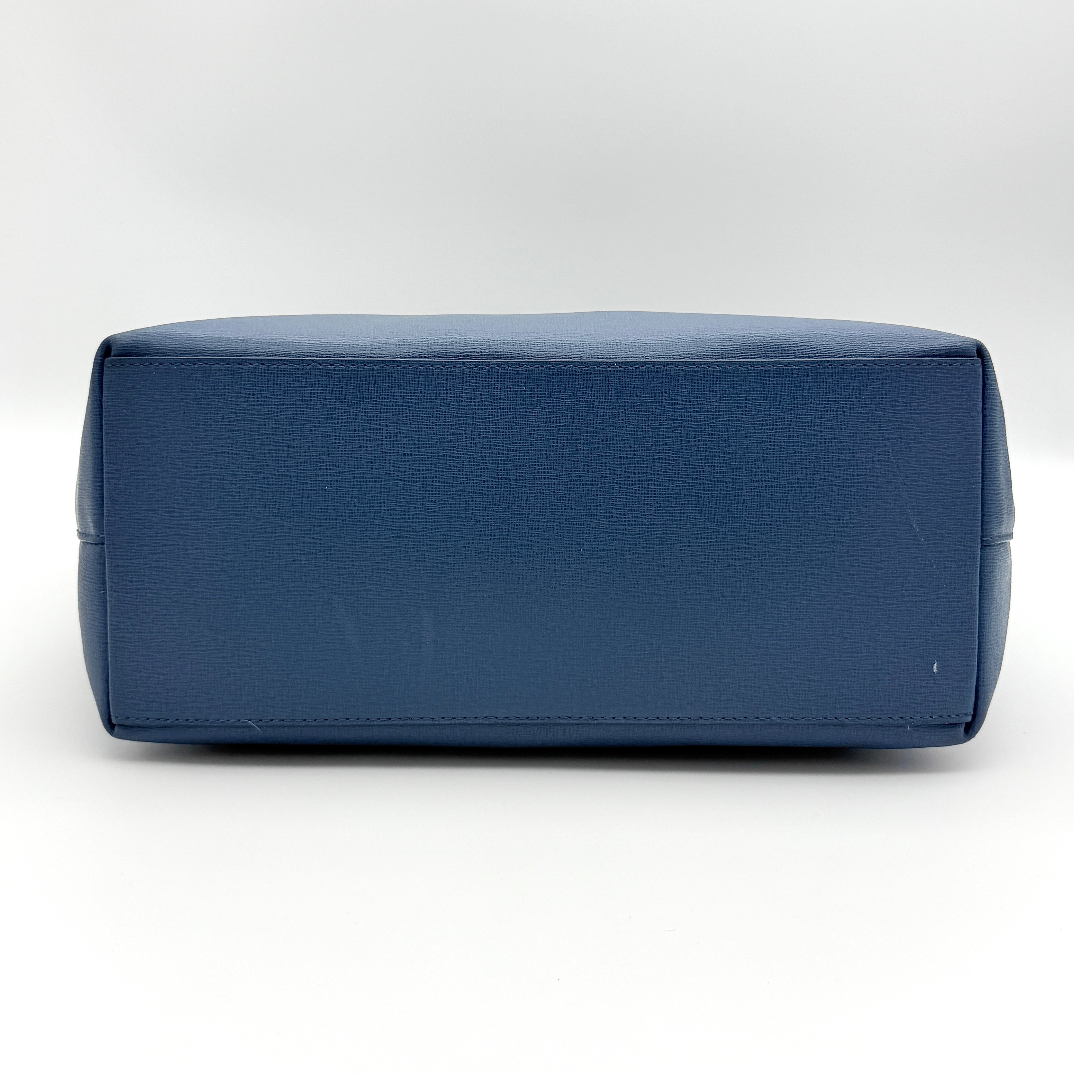 Furla New Daisy Tote Bag in blue leather with gold-tone logo charm and double handles, displayed against a white background