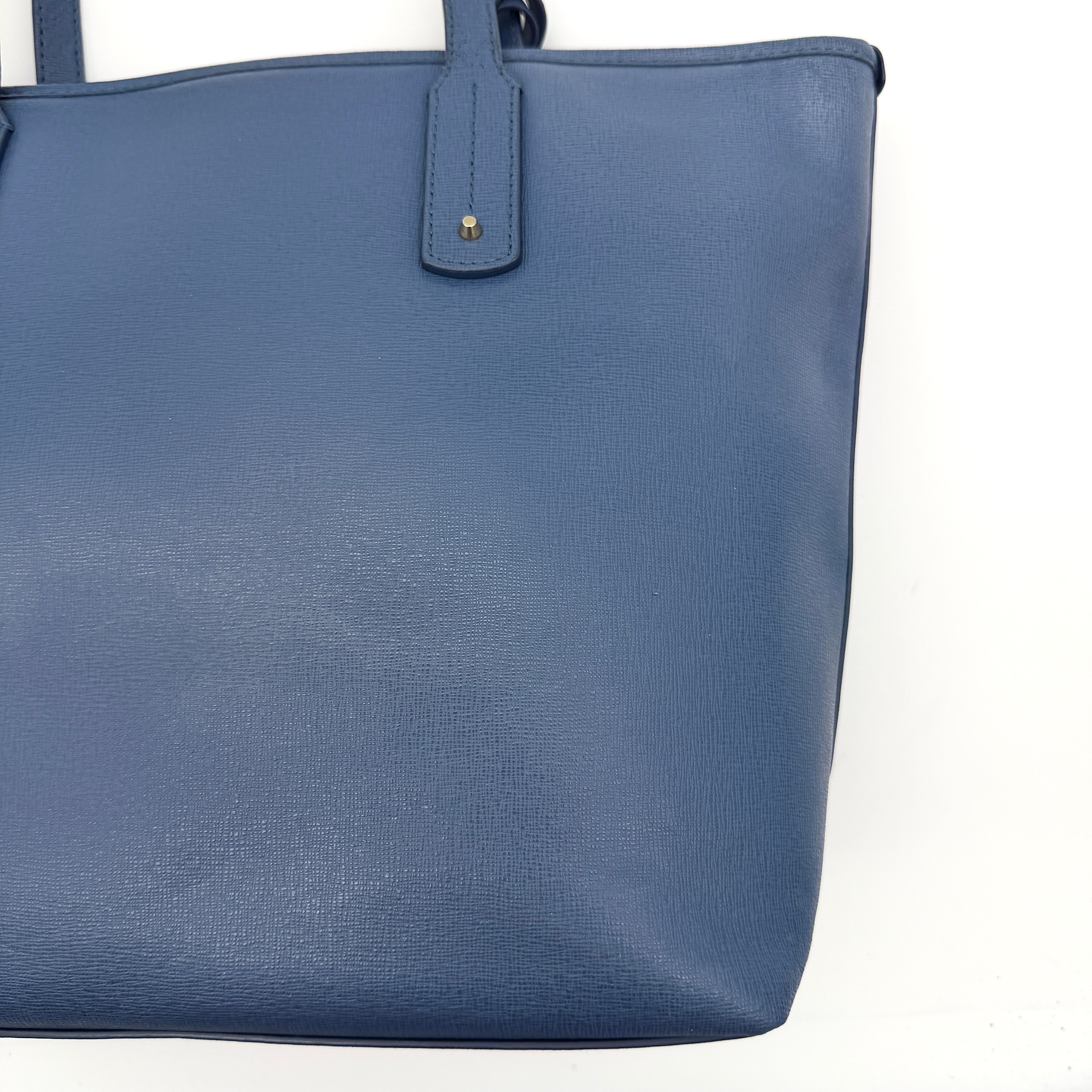 Furla New Daisy Tote Bag in blue leather with gold-tone logo charm and double handles, displayed against a white background
