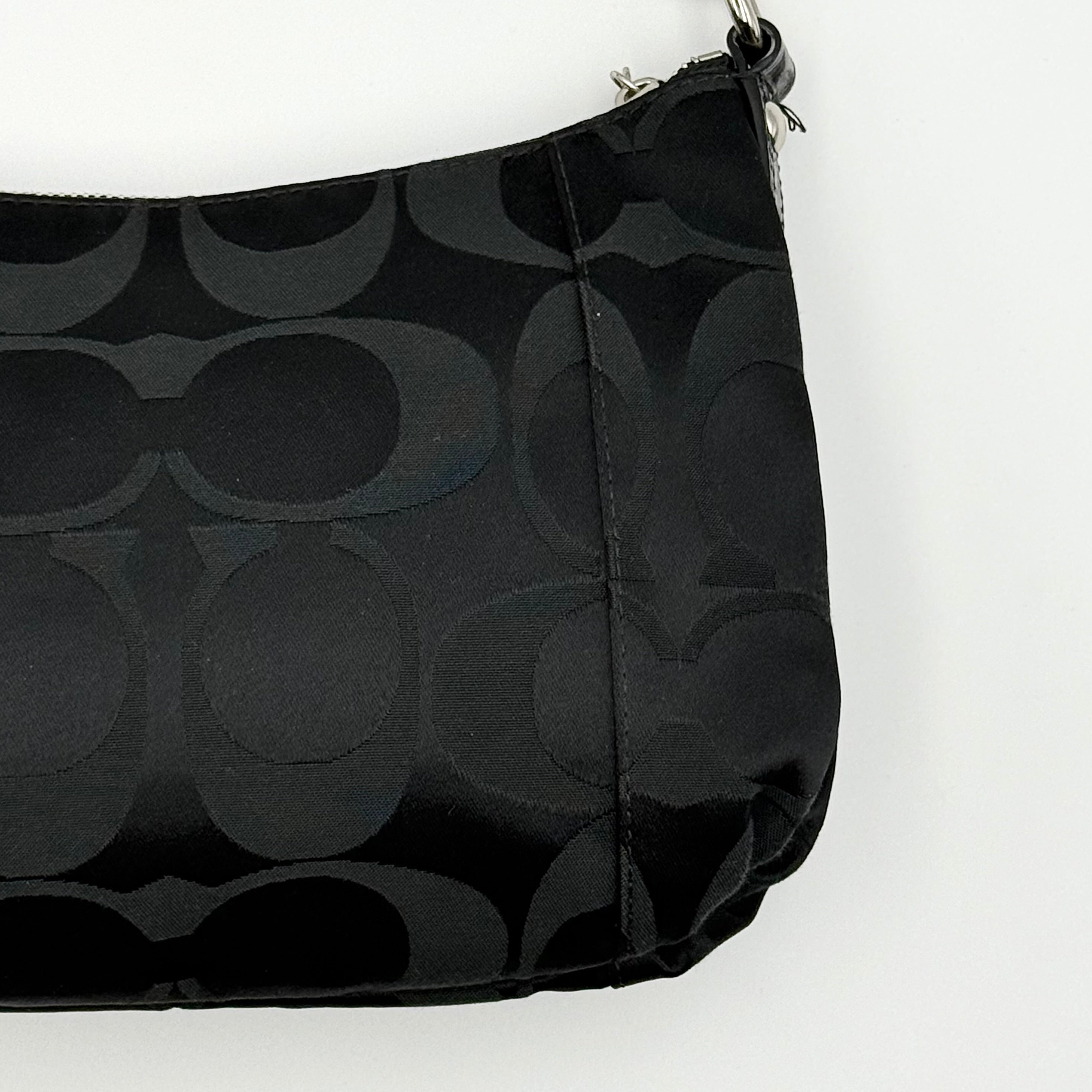Coach black Signature Poppy Shoulder Bag with silver hardware, Coach tags, and tonal jacquard finish on a white background.