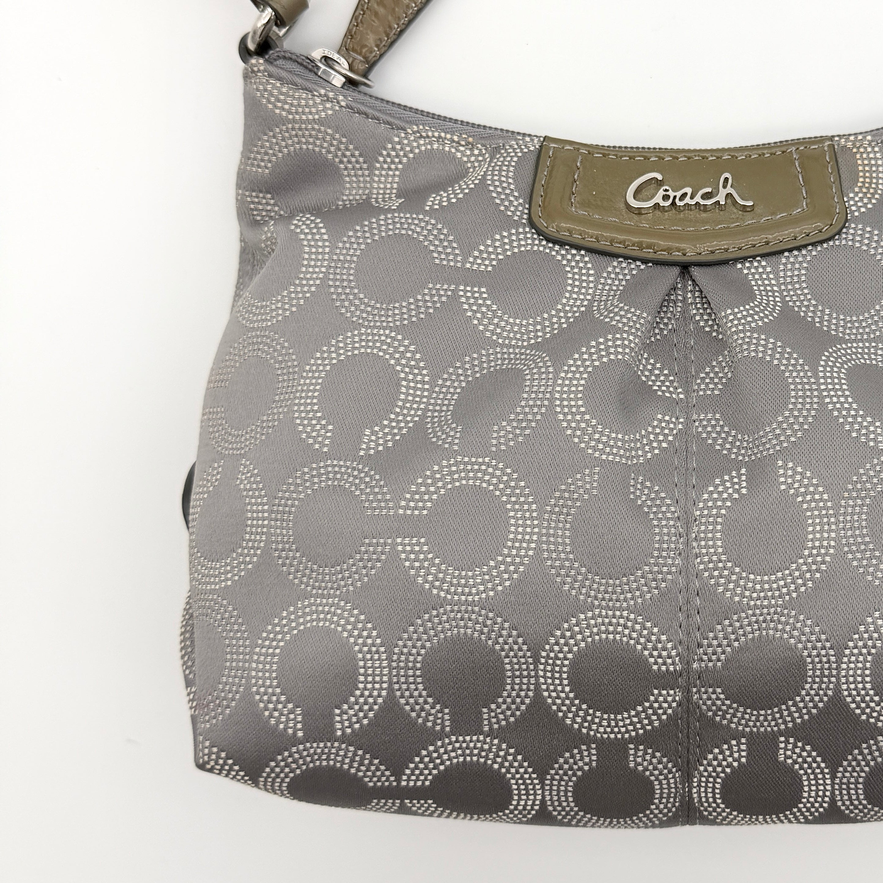 Coach Ashley Dotted Op Art crossbody bag in grey canvas with dotted monogram and adjustable strap, shown against a white background.