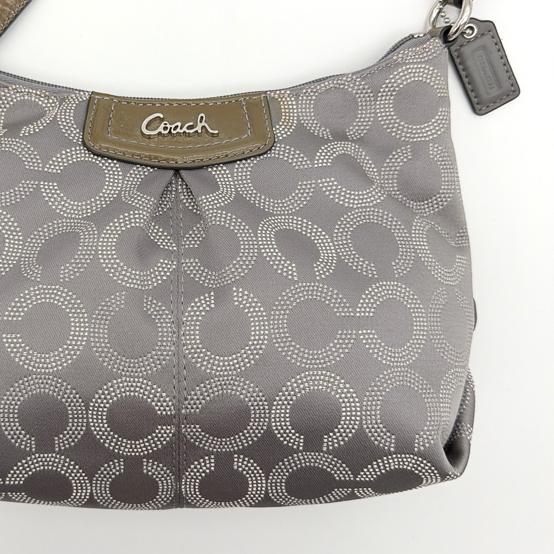 Coach Ashley Dotted Op Art crossbody bag in grey canvas with dotted monogram and adjustable strap, shown against a white background.