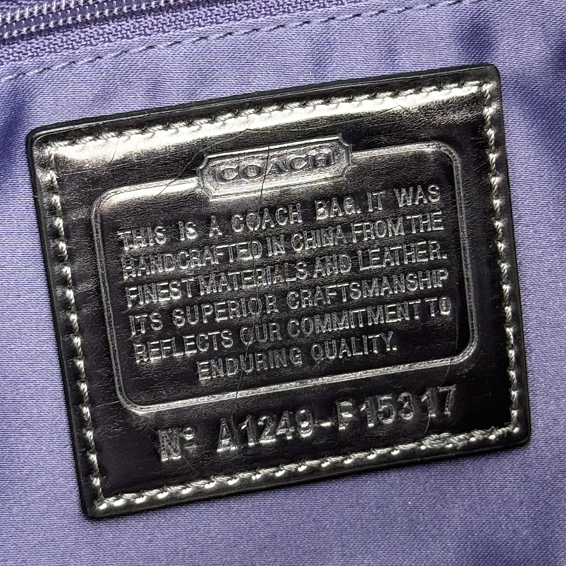 Coach black Signature Poppy Shoulder Bag with silver hardware, Coach tags, and tonal jacquard finish on a white background.