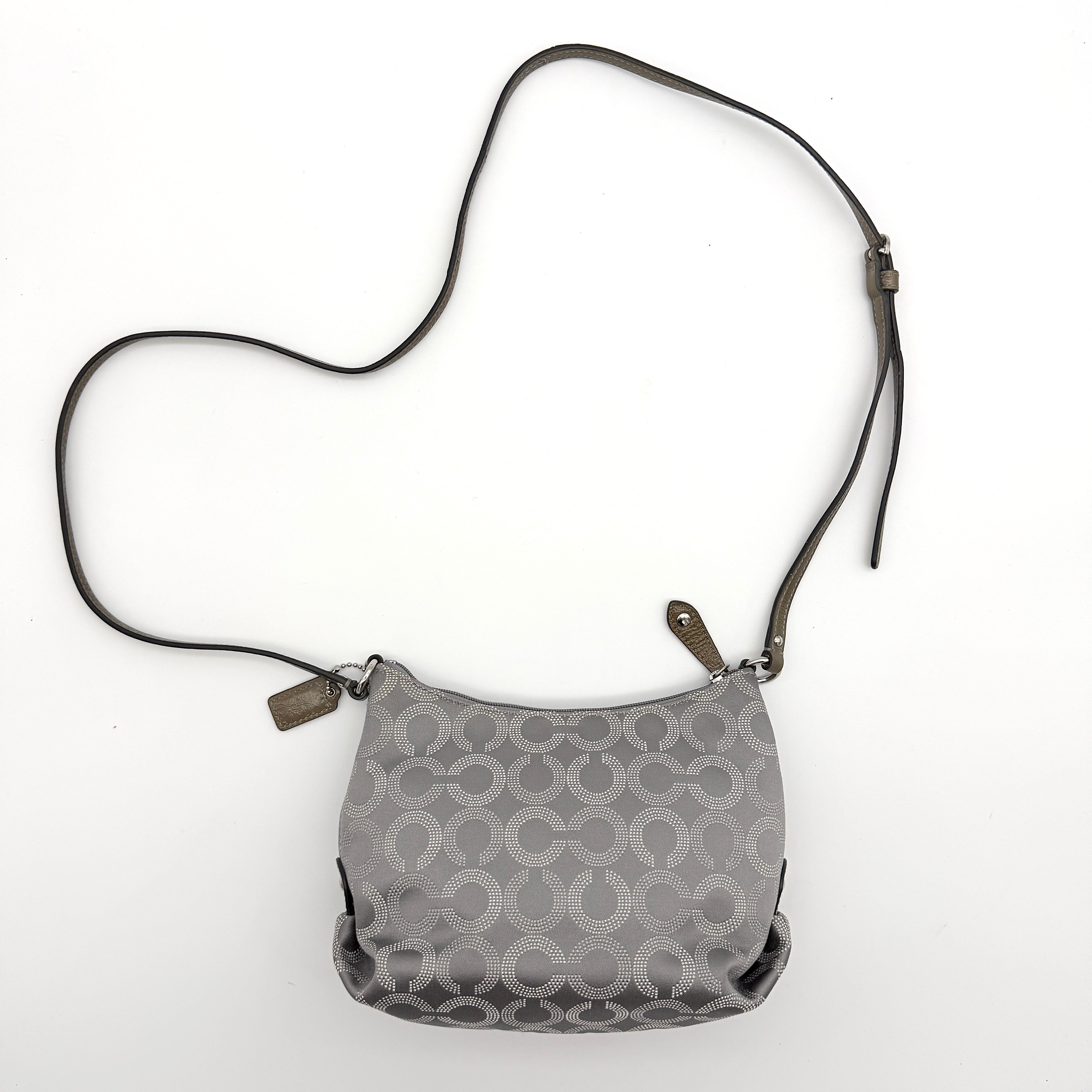 Coach Ashley Dotted Op Art crossbody bag in grey canvas with dotted monogram and adjustable strap, shown against a white background.