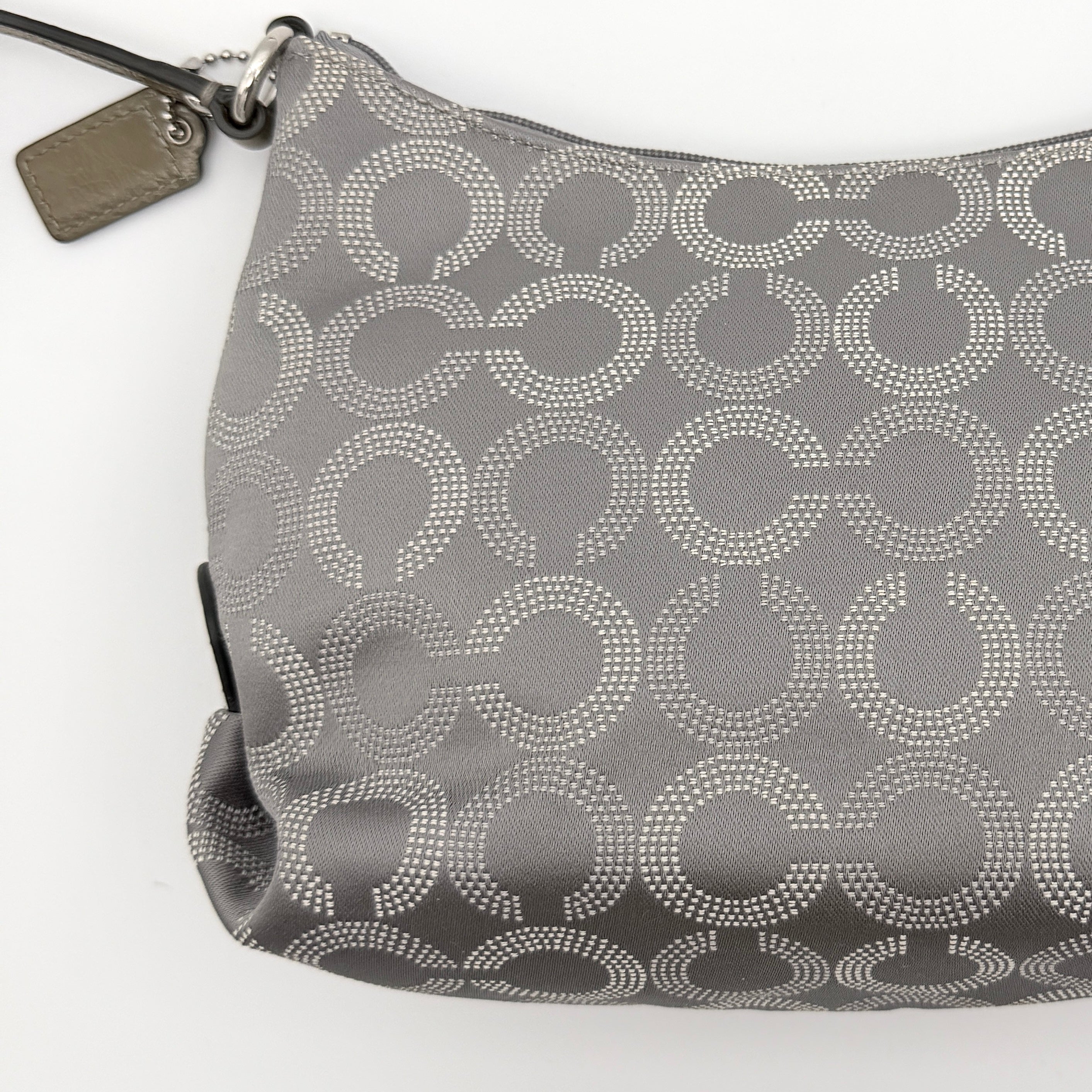 Coach Ashley Dotted Op Art crossbody bag in grey canvas with dotted monogram and adjustable strap, shown against a white background.