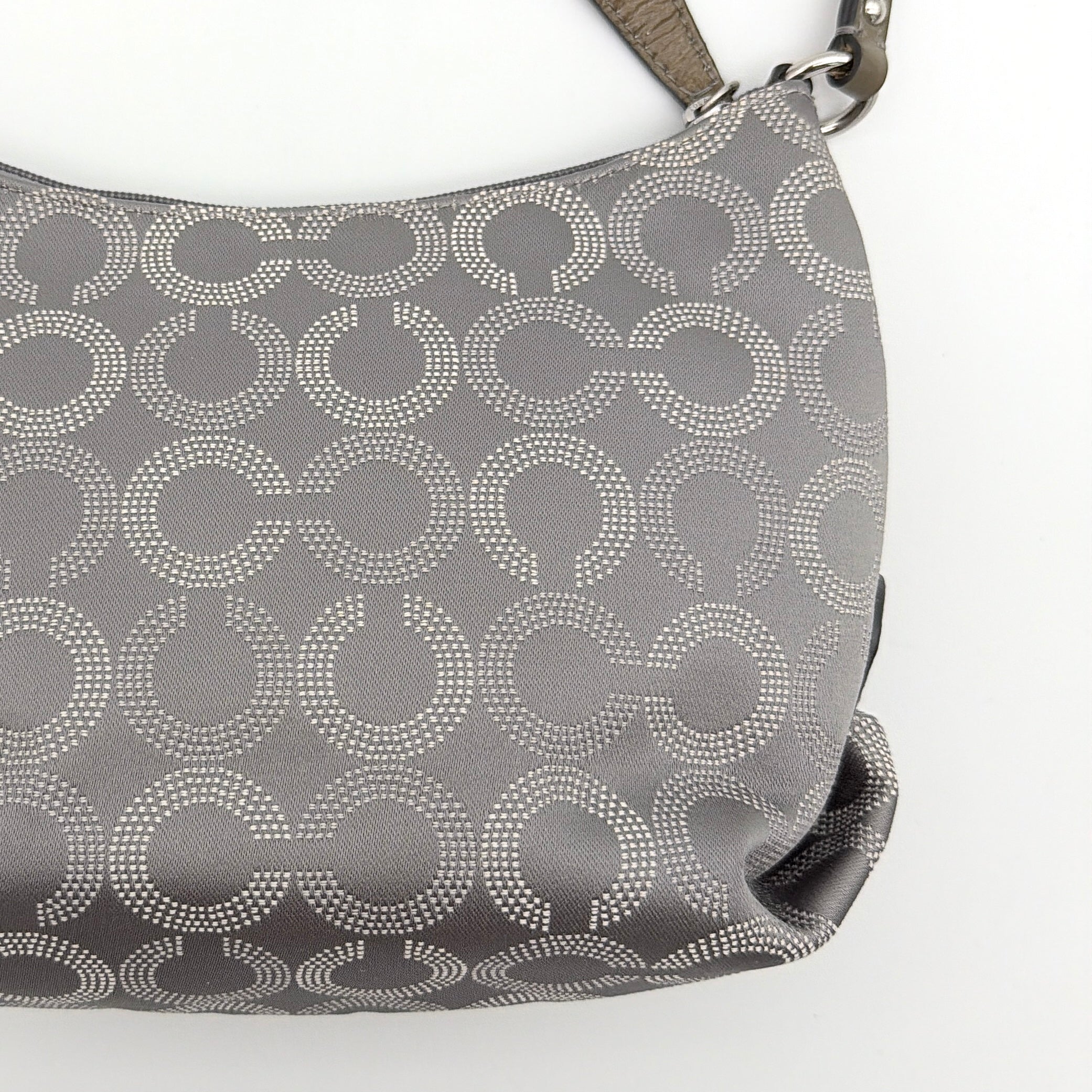 Coach Ashley Dotted Op Art crossbody bag in grey canvas with dotted monogram and adjustable strap, shown against a white background.