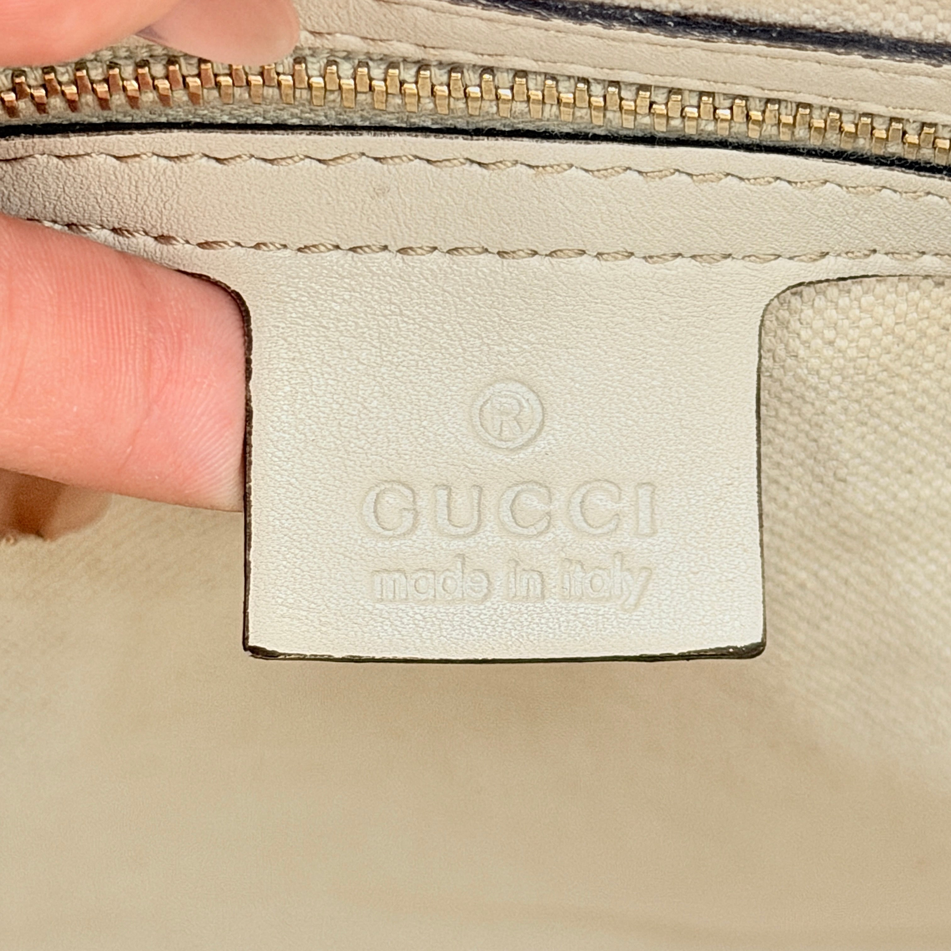 Gucci Mayfair Bow 2Way shoulder bag in cream GG monogram leather with dual handles and detachable strap, styled against a neutral backdrop.