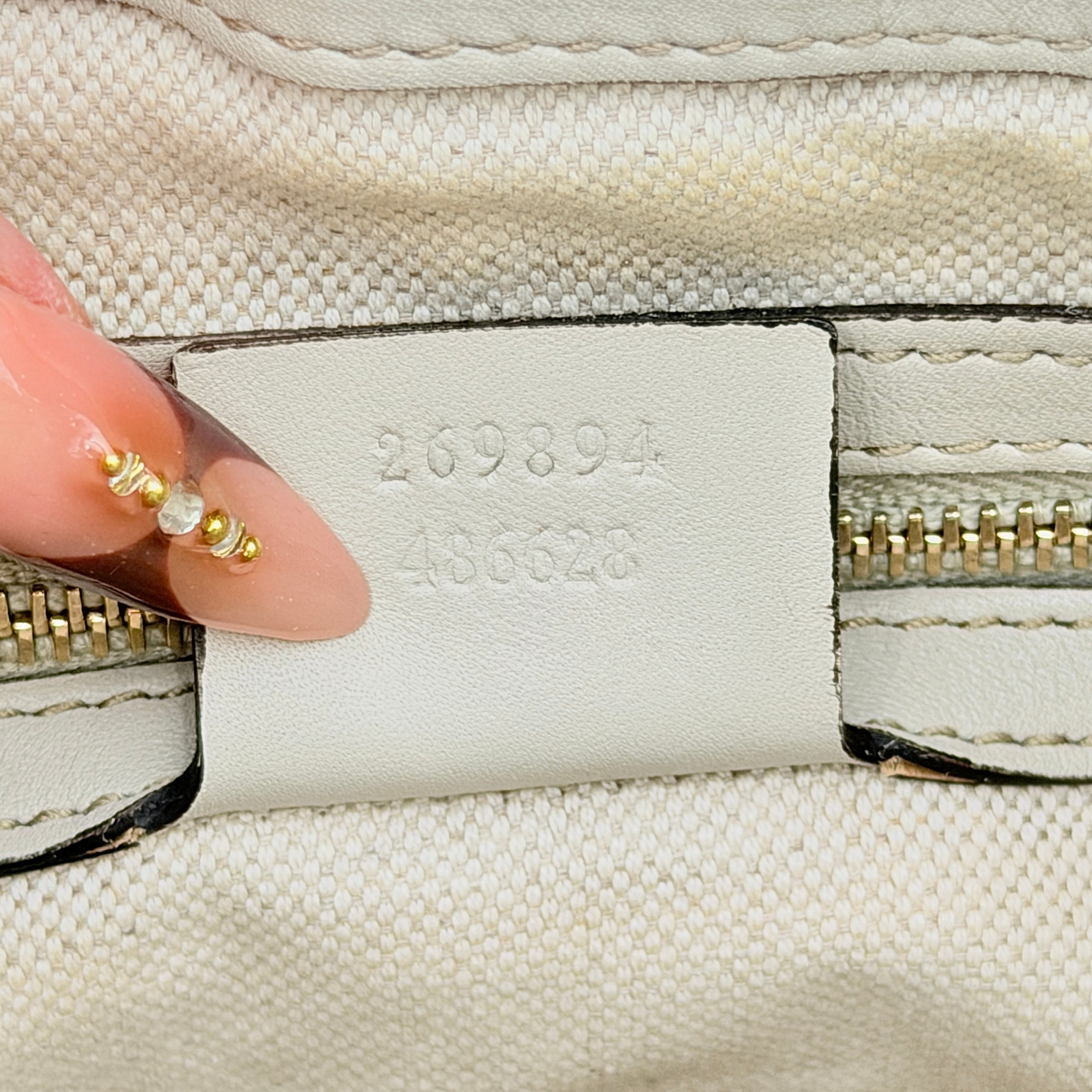 Gucci Mayfair Bow 2Way shoulder bag in cream GG monogram leather with dual handles and detachable strap, styled against a neutral backdrop.