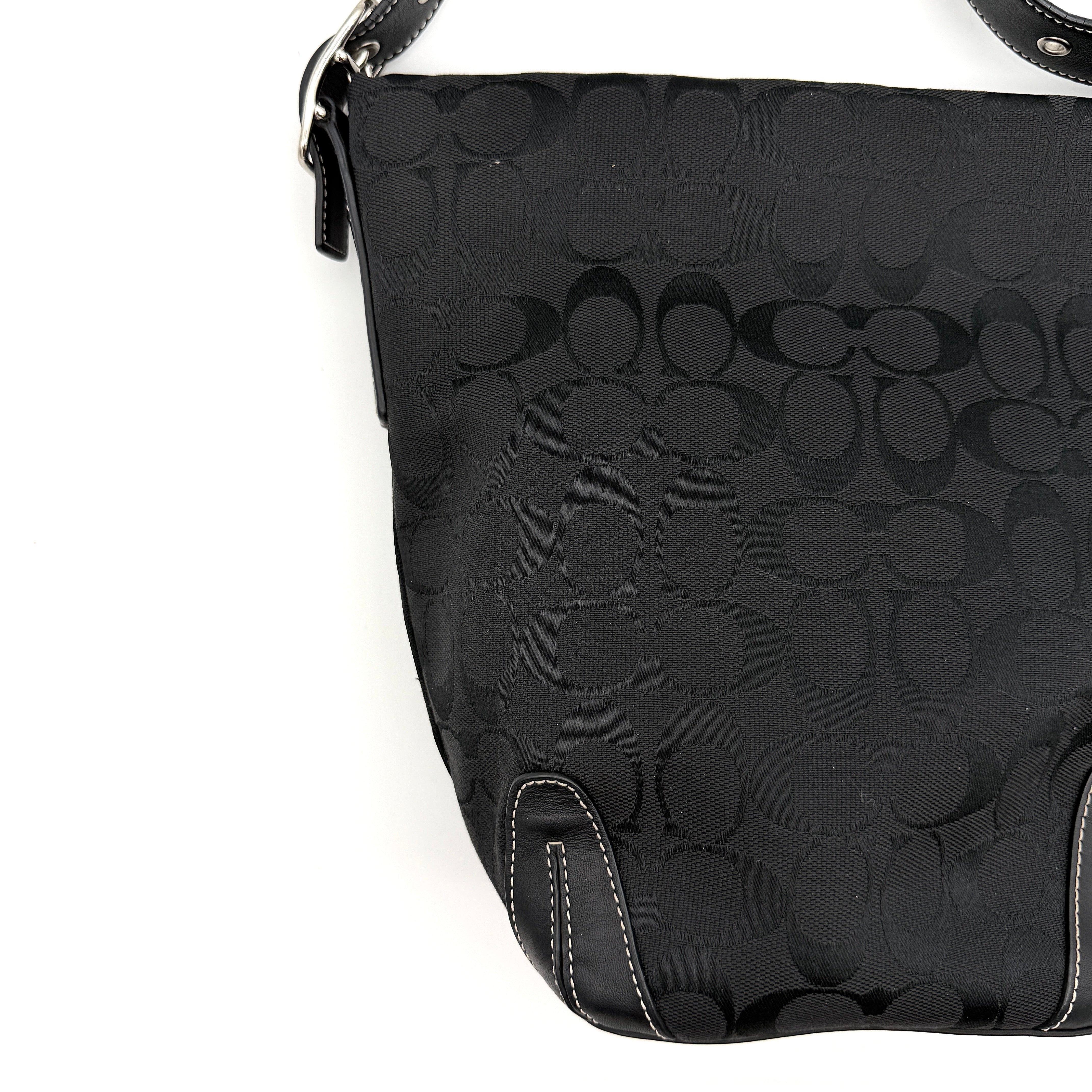Coach black Signature Bucket Hobo bag with jacquard monogram, leather trim, and adjustable shoulder strap.