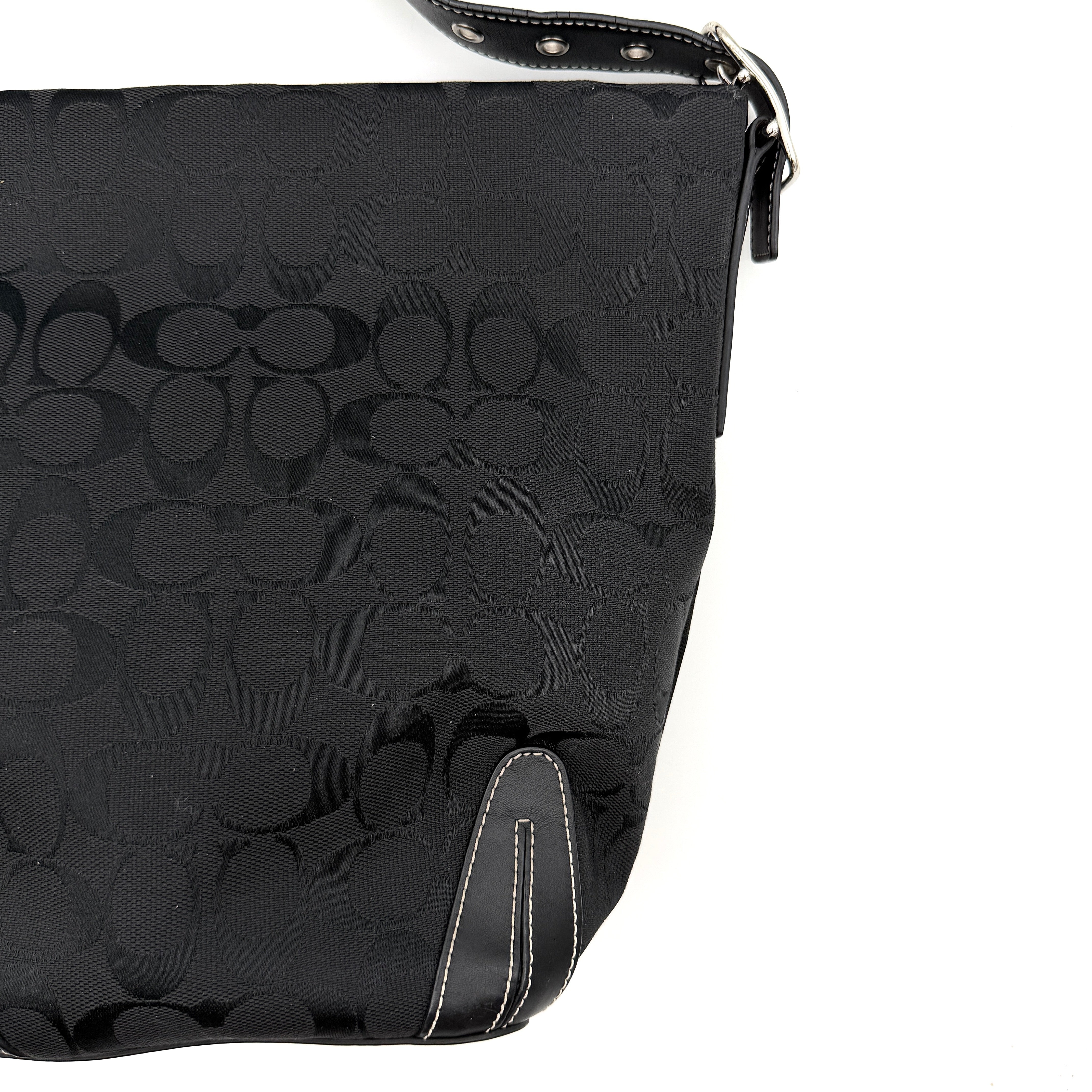 Coach black Signature Bucket Hobo bag with jacquard monogram, leather trim, and adjustable shoulder strap.