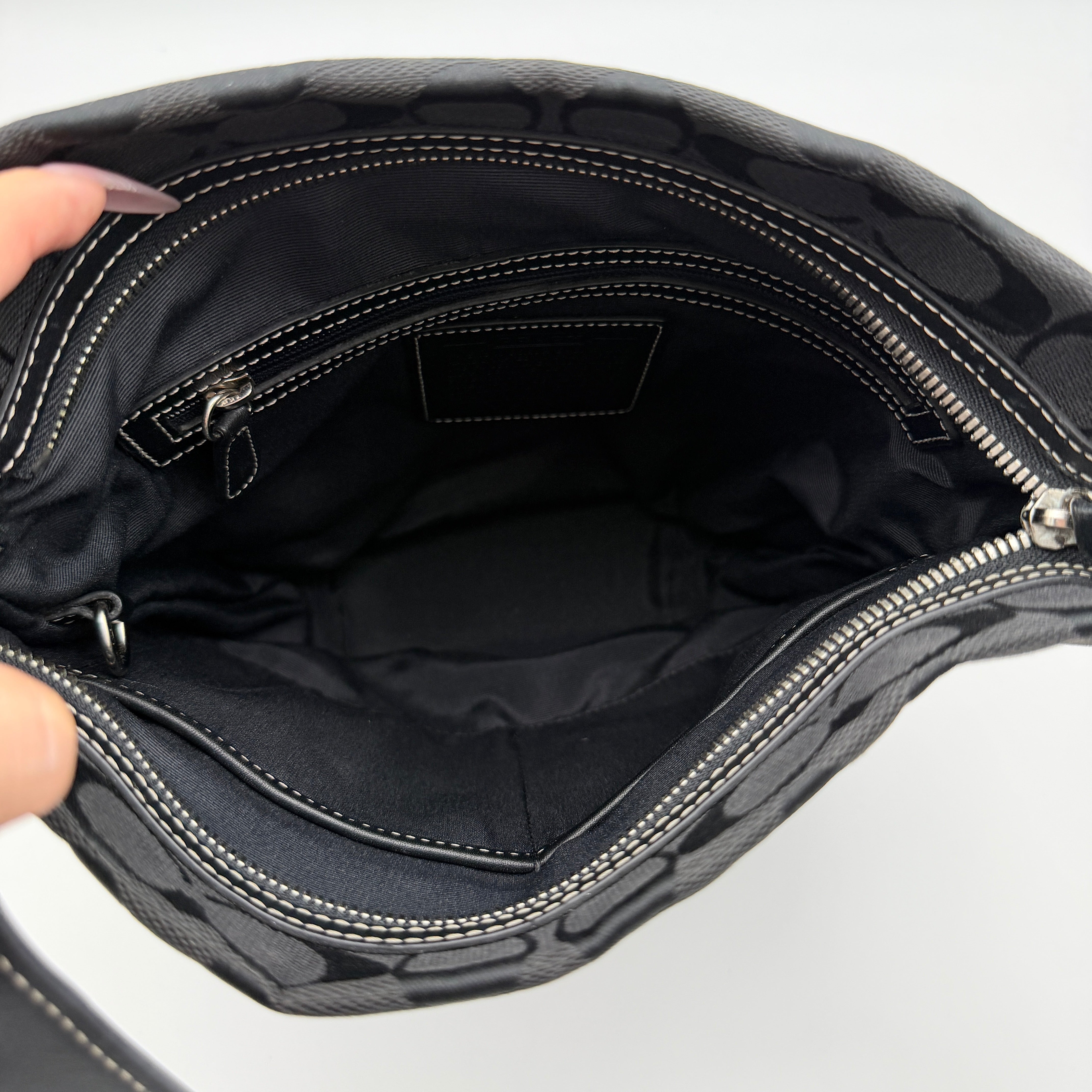 Coach black Signature Bucket Hobo bag with jacquard monogram, leather trim, and adjustable shoulder strap.