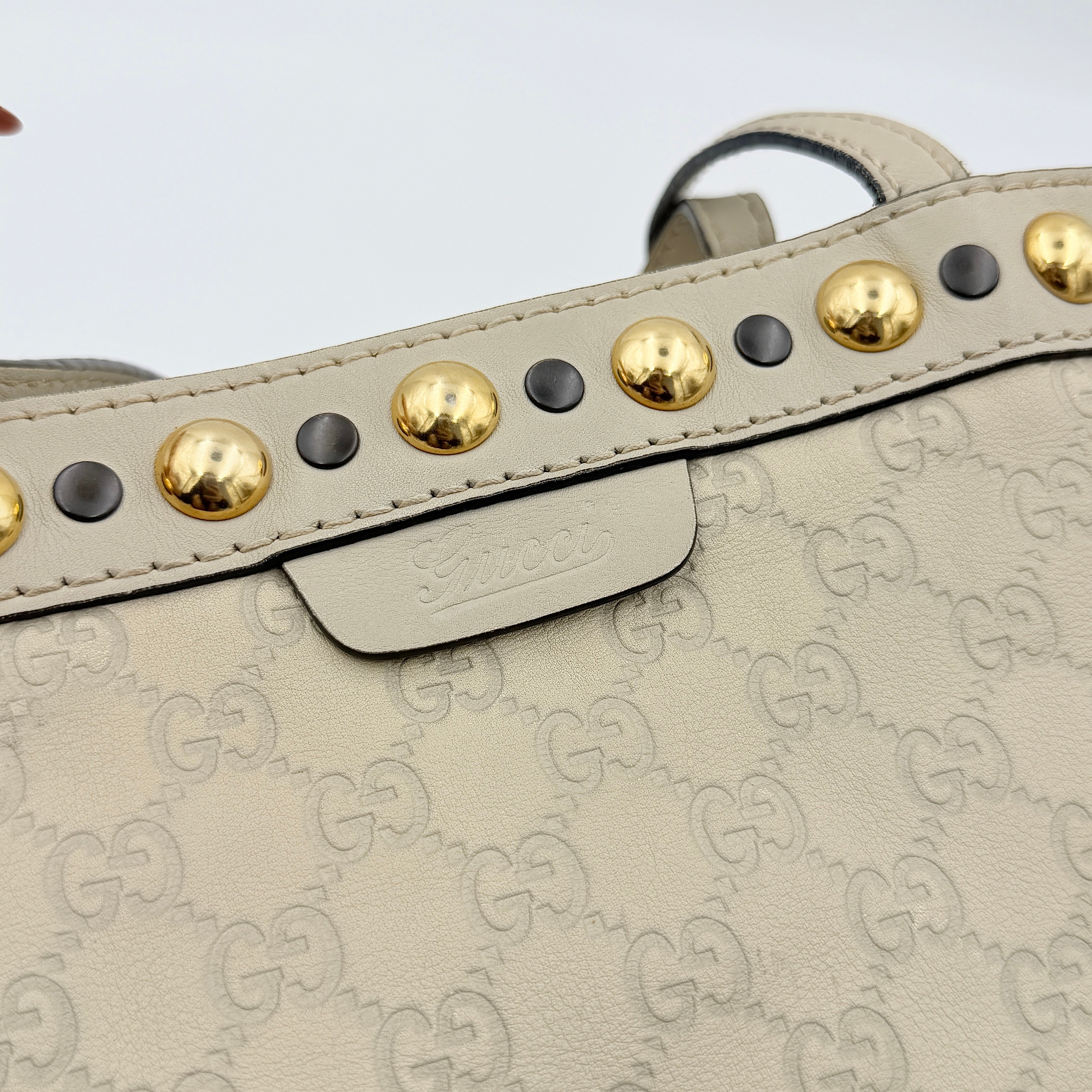 Gucci GG Monogram Babouska shoulder bag in cream canvas with gold-tone stud details and double top handles.