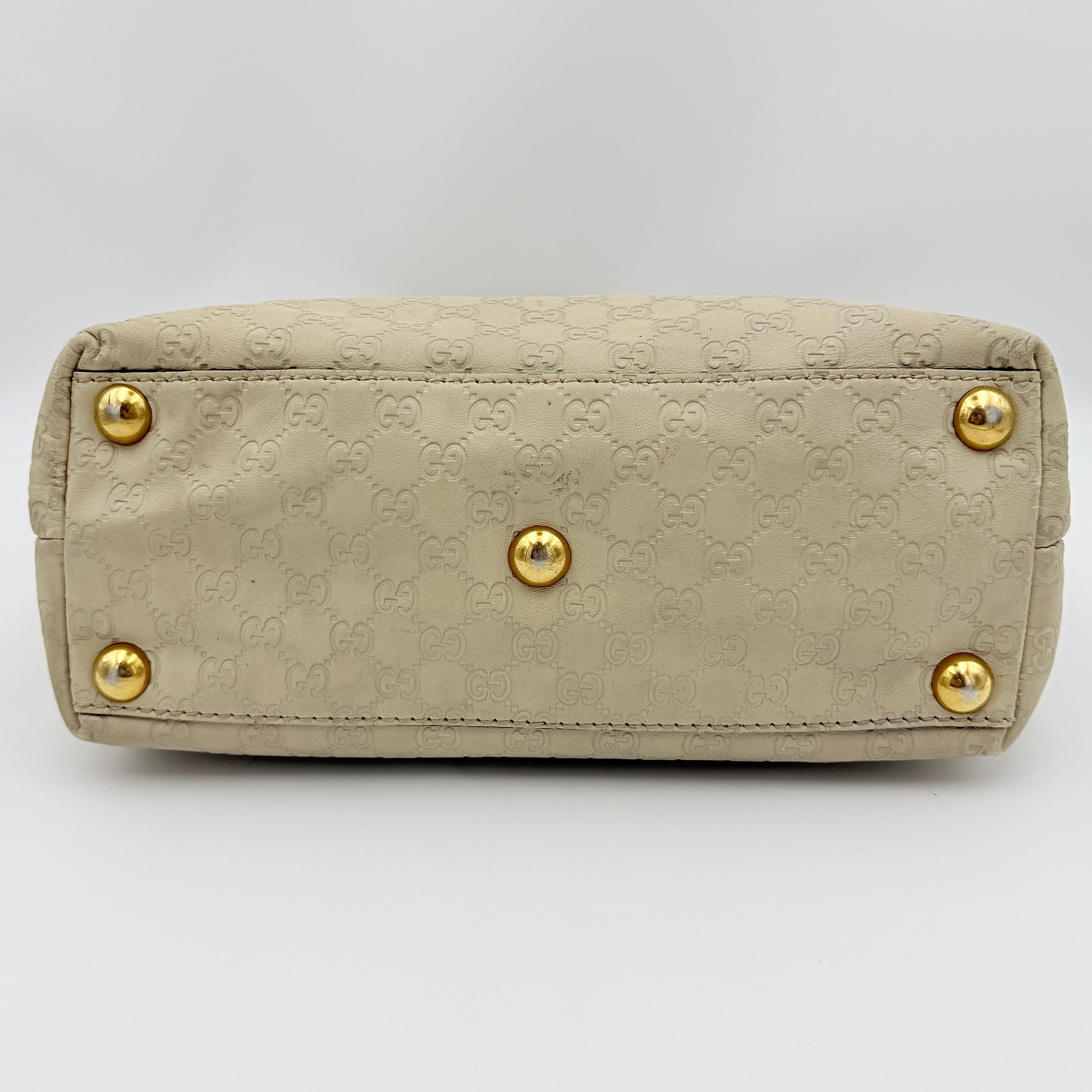 Gucci GG Monogram Babouska shoulder bag in cream canvas with gold-tone stud details and double top handles.