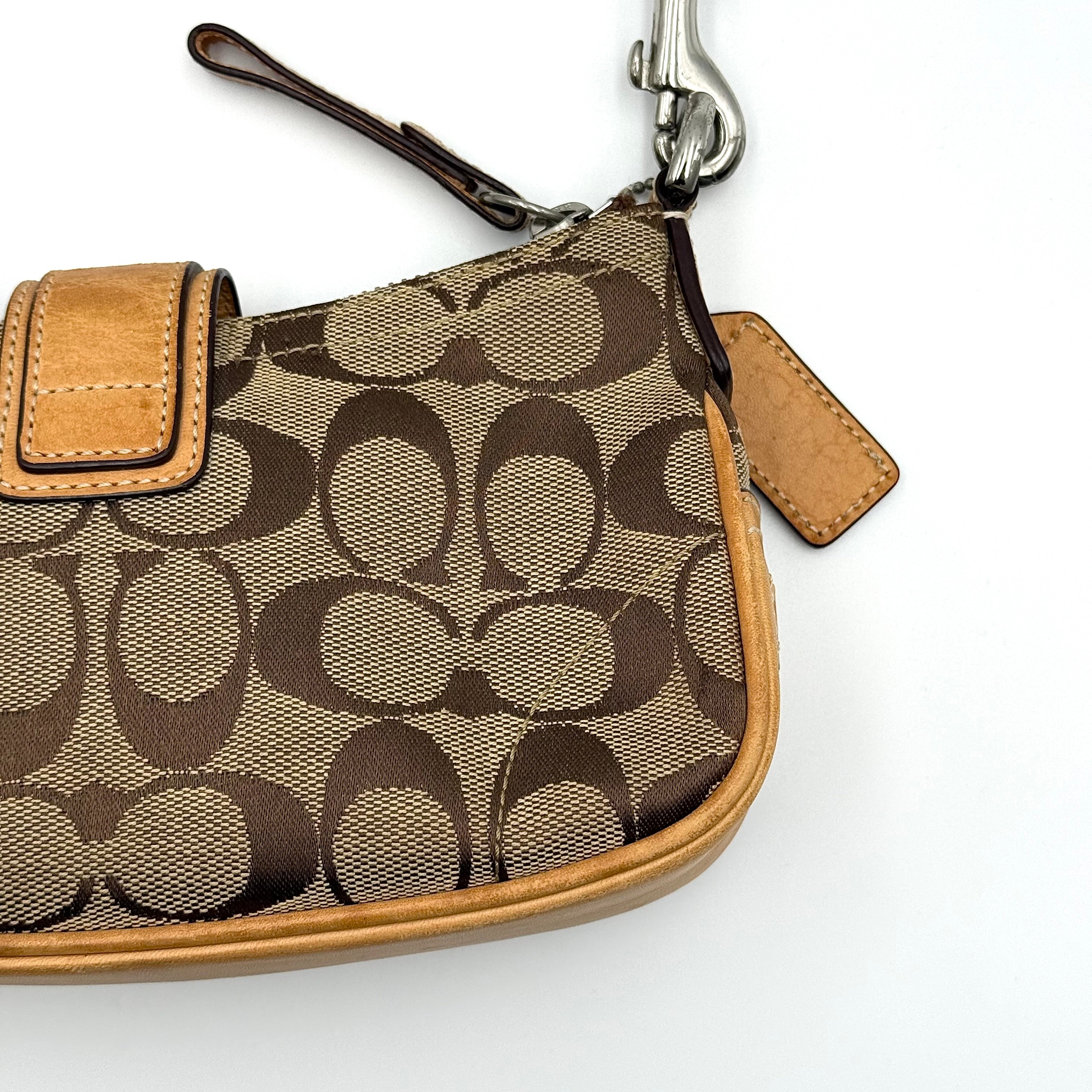 Coach Soho Demi shoulder bag in beige and tan monogram canvas with leather trim and buckle detail.