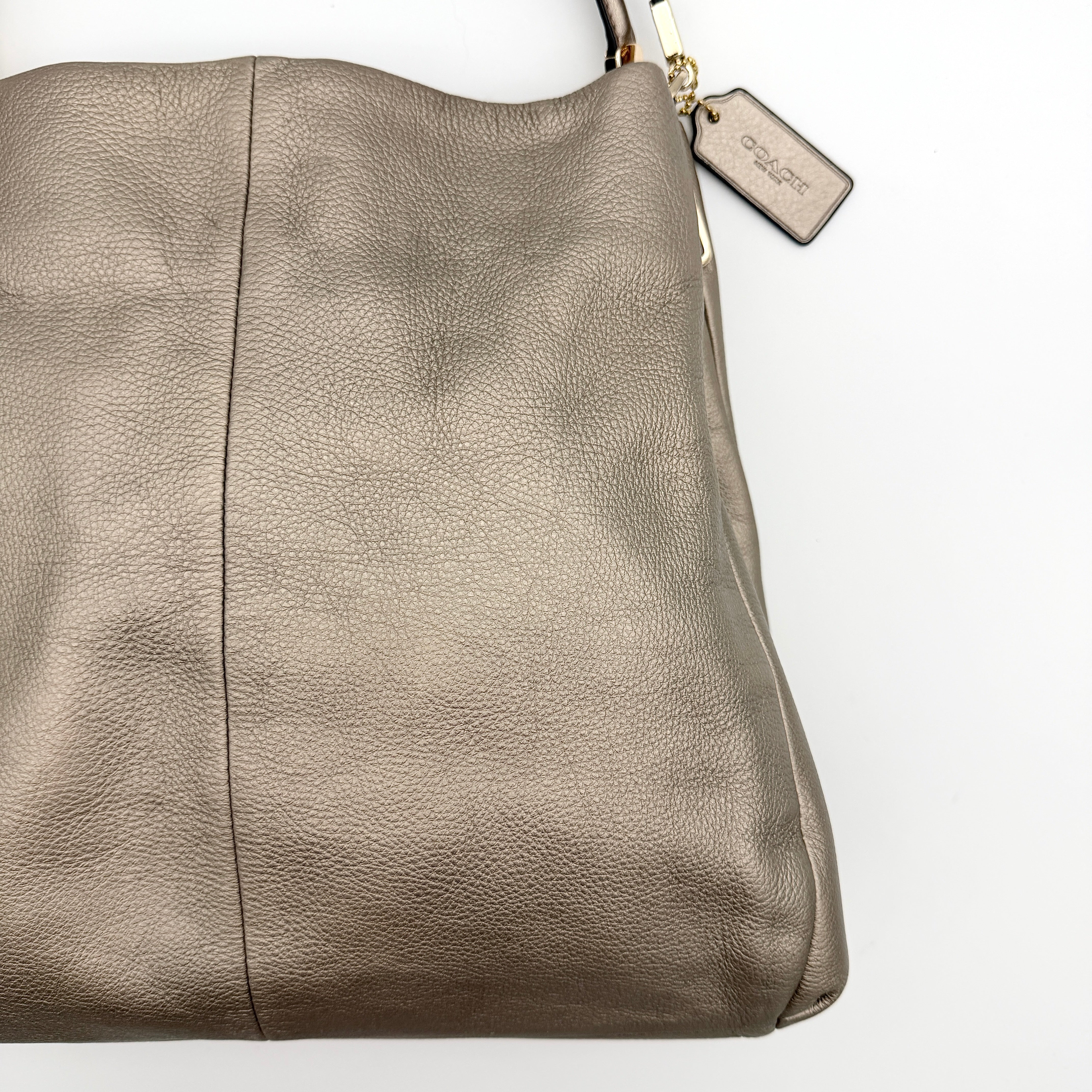 Coach Madison Phoebe shoulder bag in metallic taupe pebbled leather with dual straps and gold-tone hardware.
