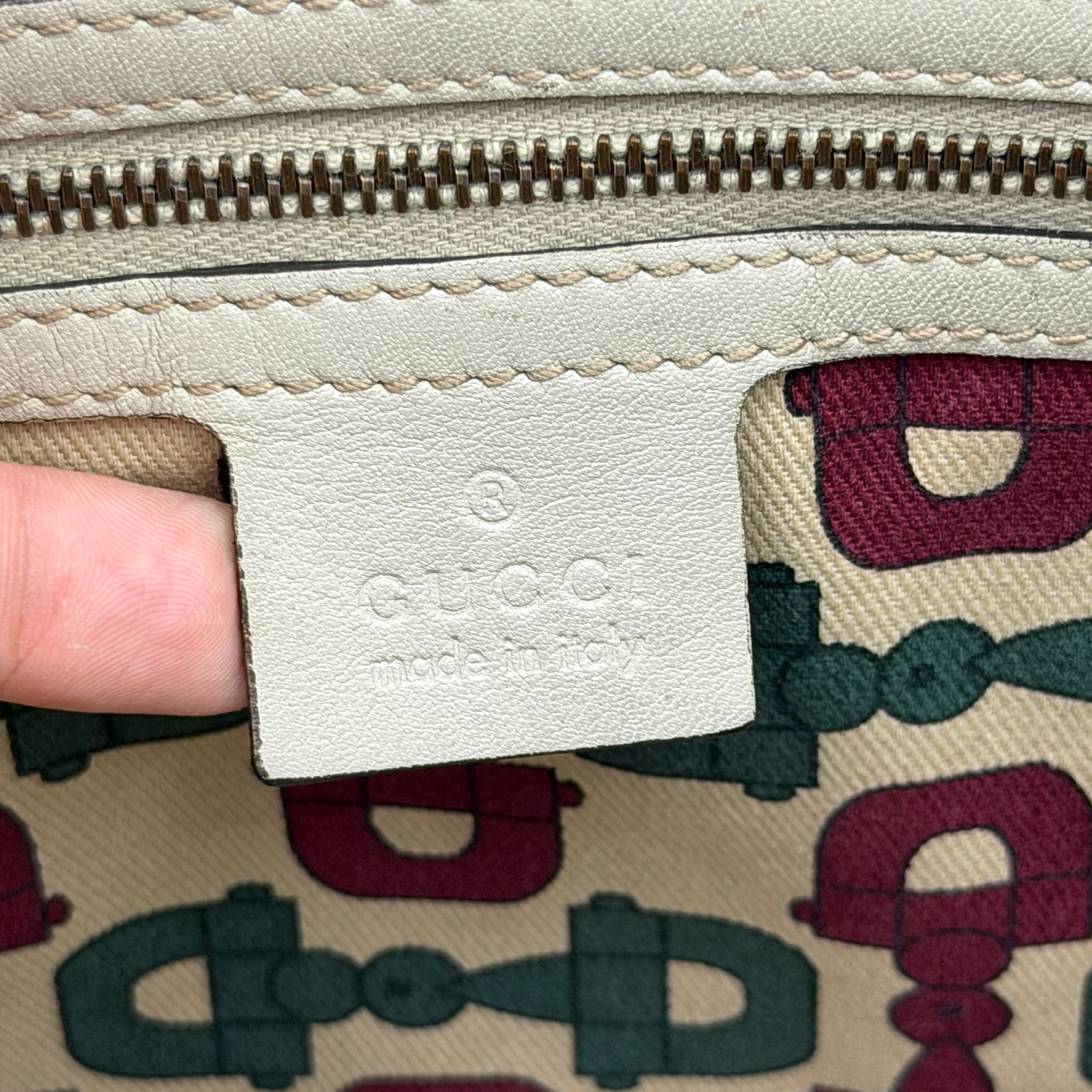 Gucci GG Monogram Babouska shoulder bag in cream canvas with gold-tone stud details and double top handles.