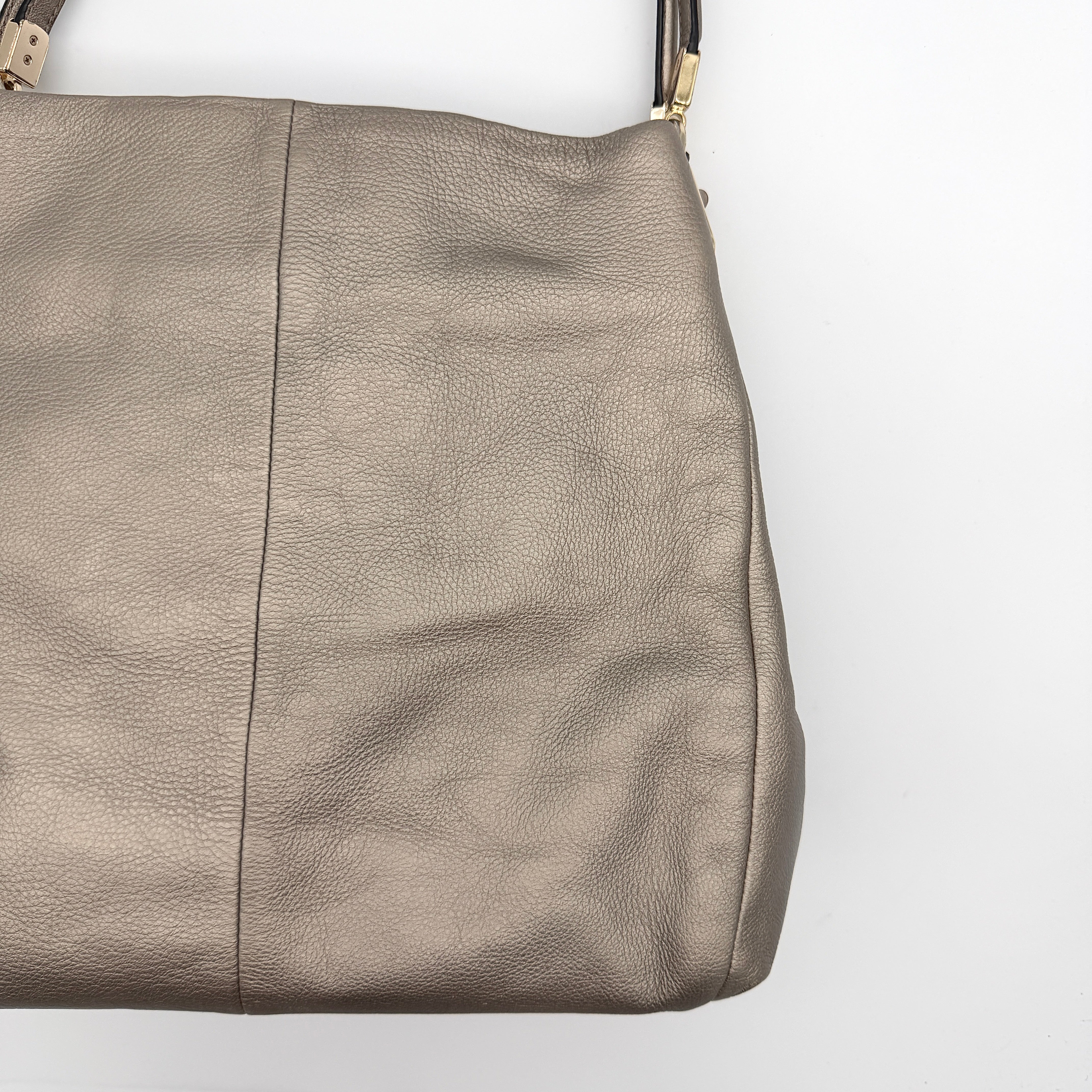 Coach Madison Phoebe shoulder bag in metallic taupe pebbled leather with dual straps and gold-tone hardware.