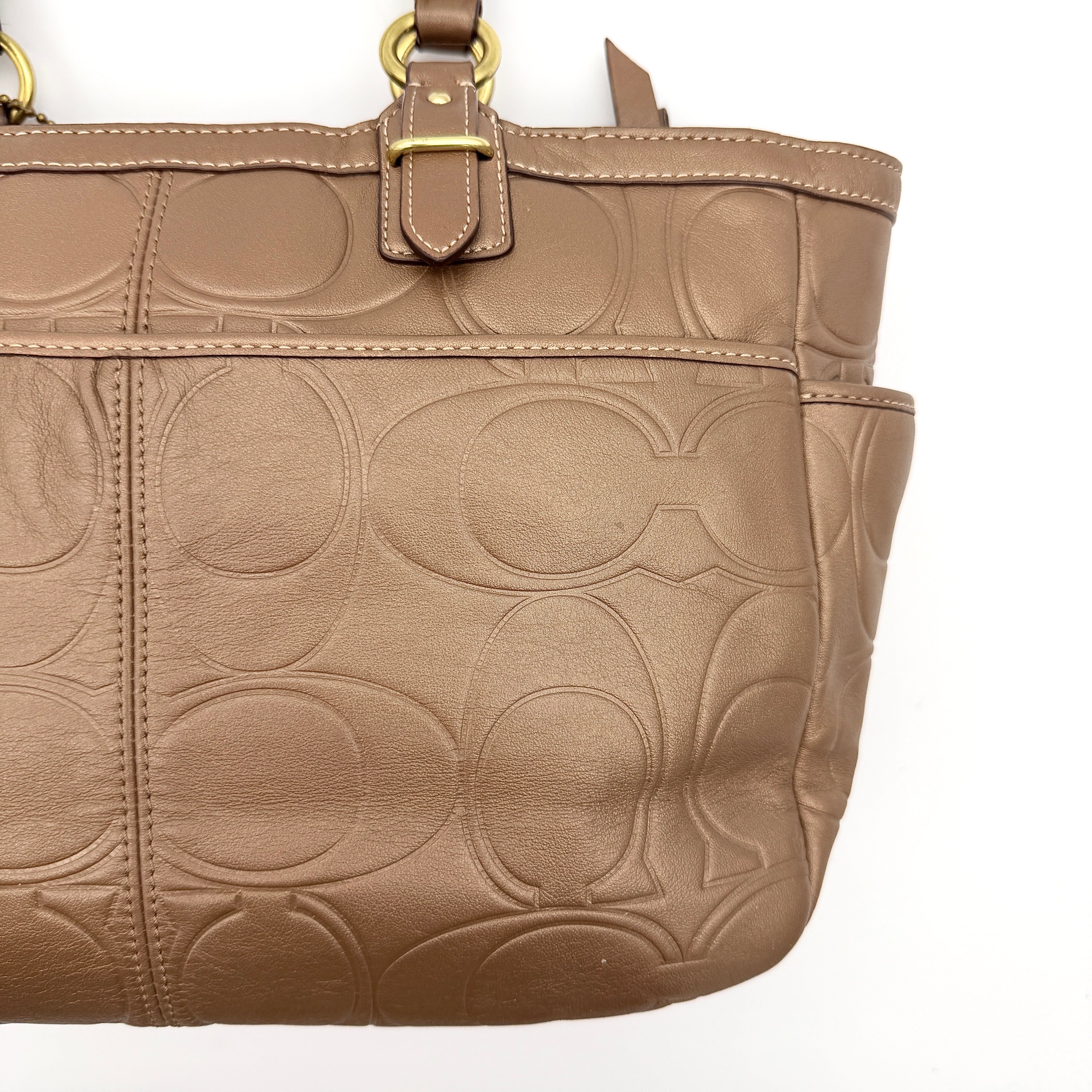 Coach Signature Gallery embossed leather tote bag in brown with gold tone hardware and dual handles.