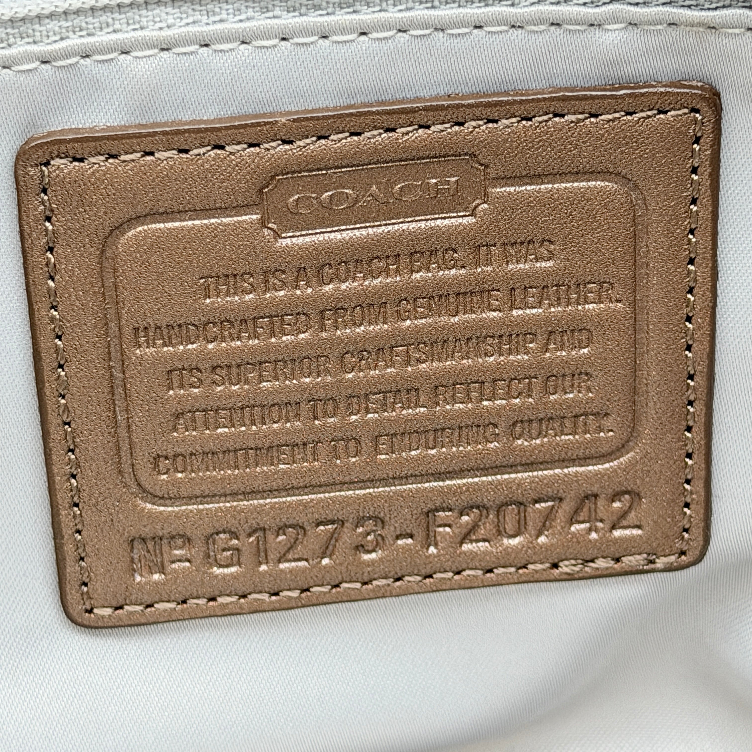 Coach Signature Gallery embossed leather tote bag in brown with gold tone hardware and dual handles.