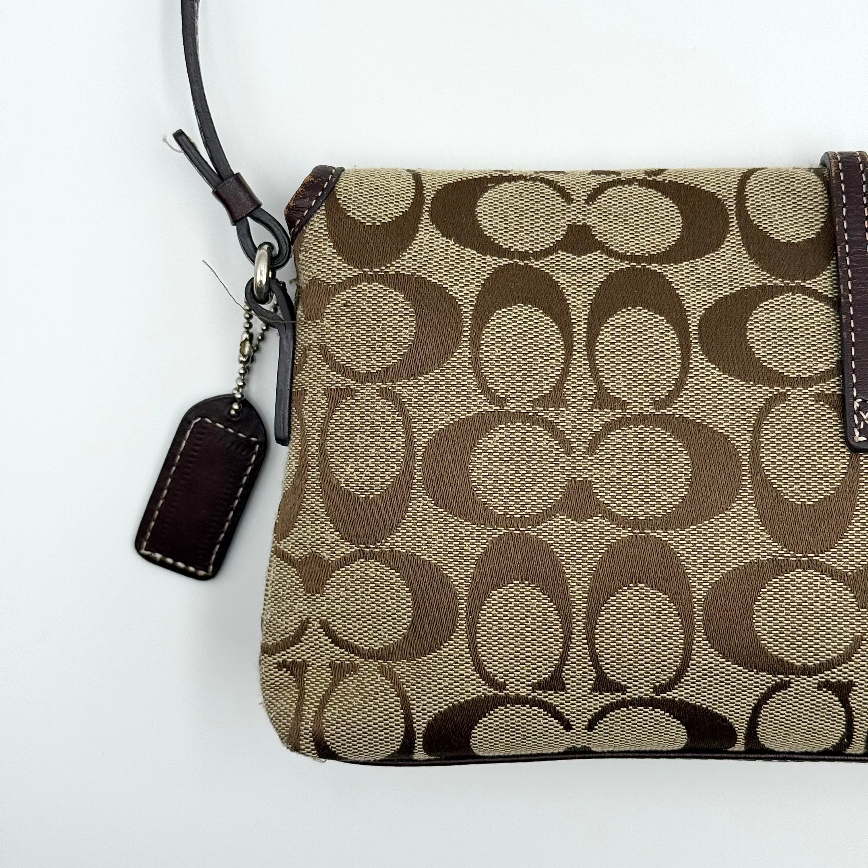 Coach Y2K Demi Clip Baguette in beige and brown canvas with leather trim, featuring signature monogram and shoulder strap.