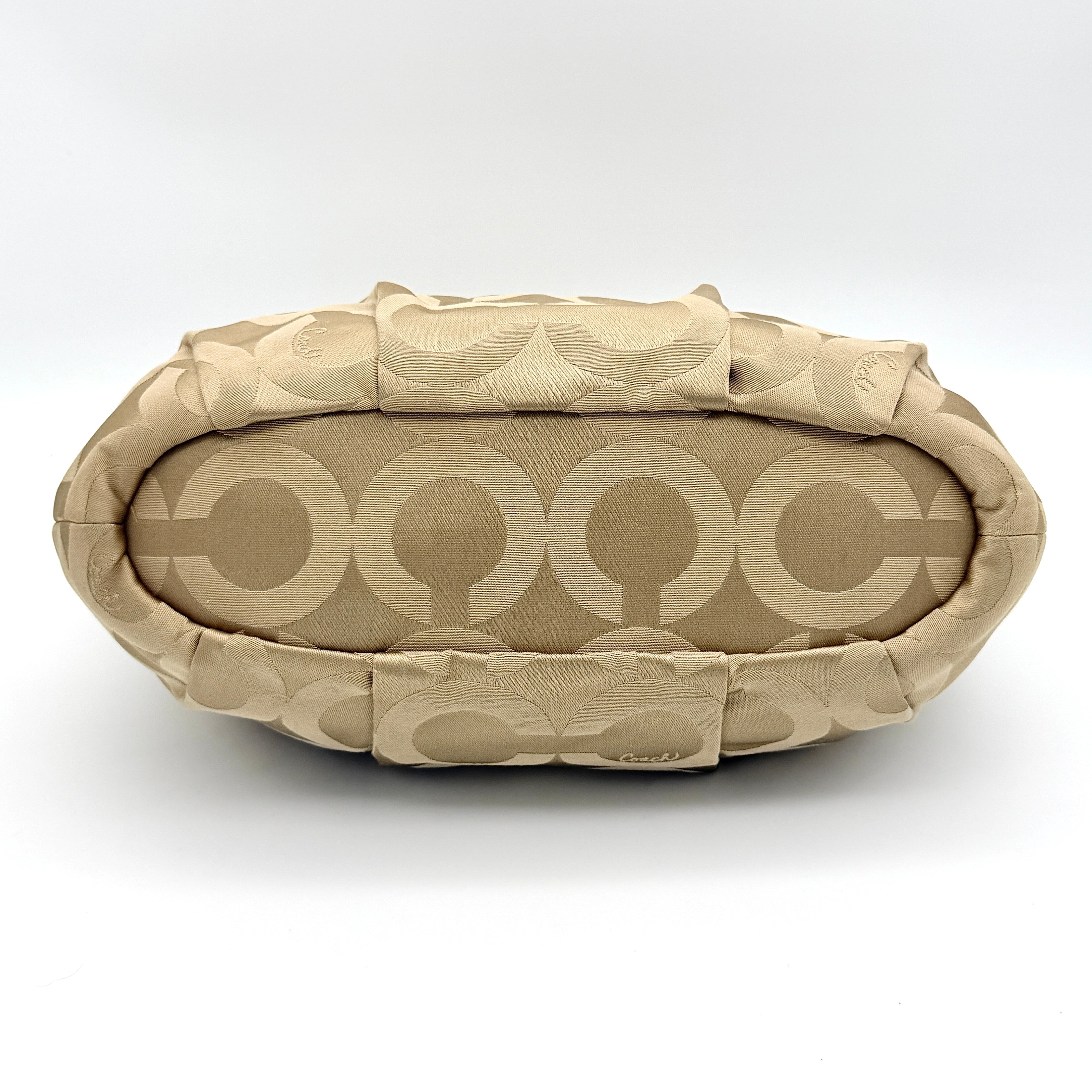 Beige Coach Madison Op Art Sophia shoulder bag with ivory leather handles, gold hardware, and detachable strap.